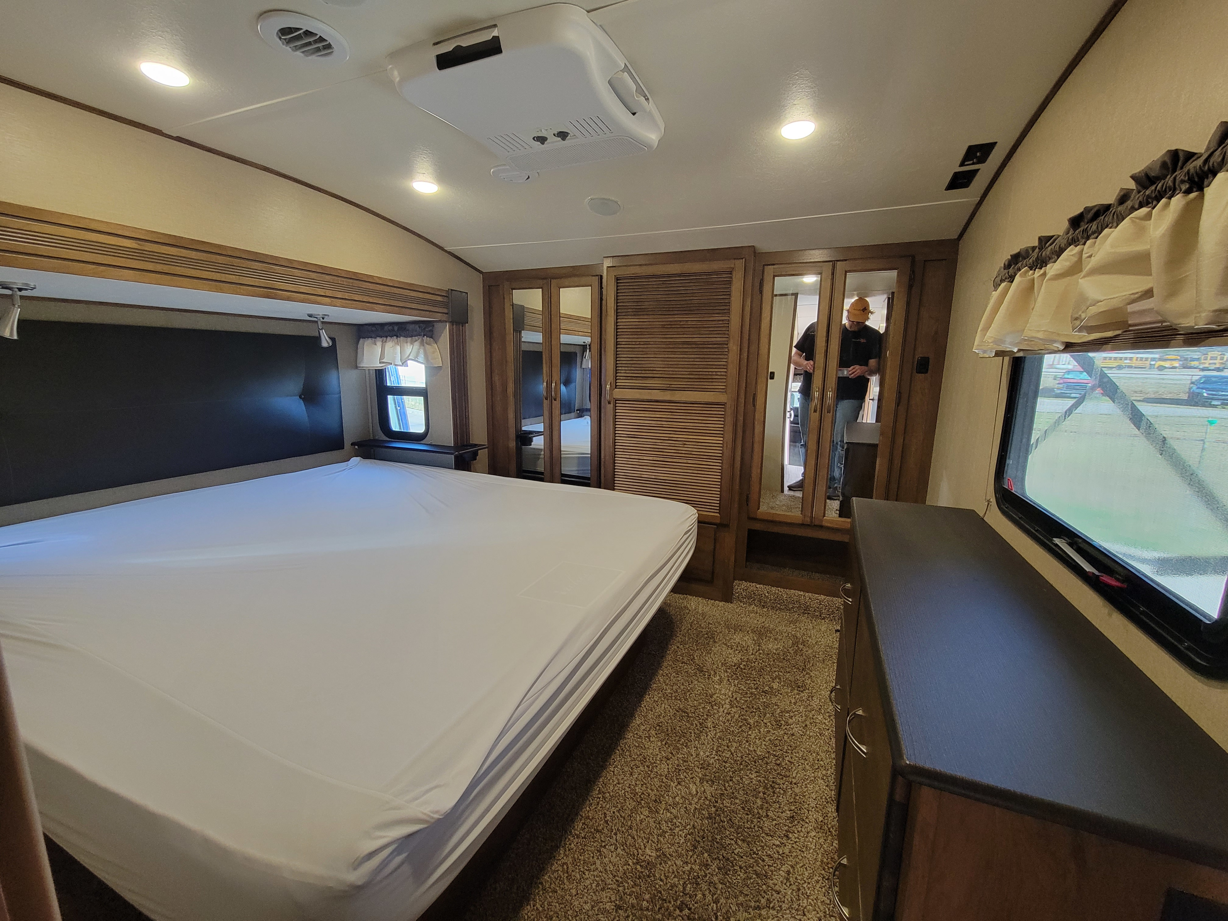 Spacious RV rental bedroom with a comfortable bed, mirrored wardrobe, and overhead AC unit.. Forest River Chaparral 2017
