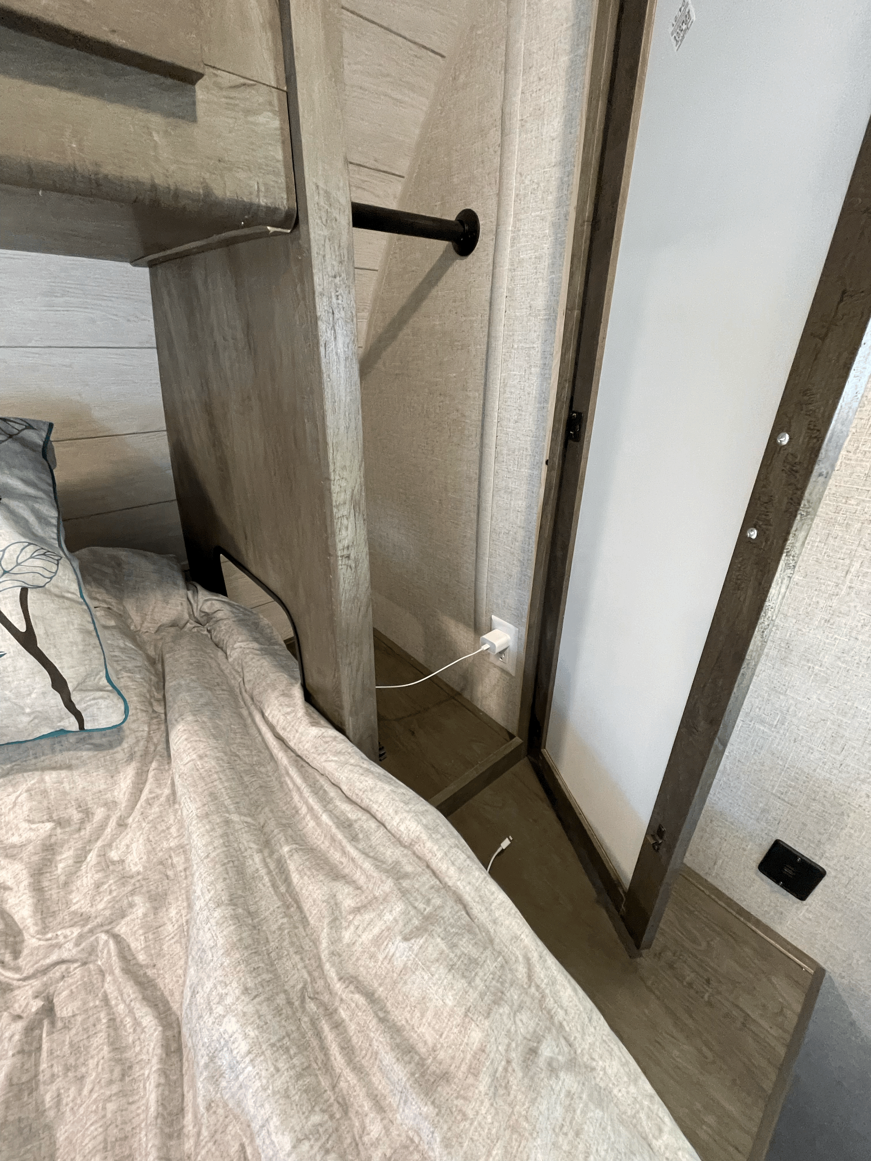 RV rental bedroom interior: compact storage with hanging rod, bed, and convenient charging outlet.. Forest River Other 2021