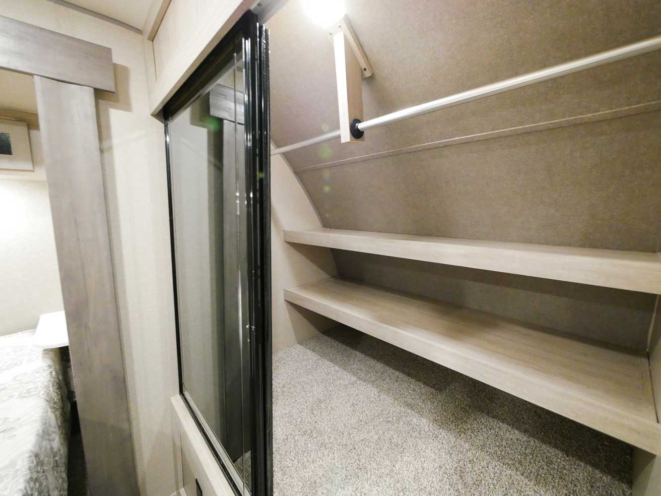 RV rental: Well-organized interior closet with shelves, hanging rod, and carpeted floor, adjacent to the bedroom.. Forest River Coachmen Catalina Legacy Edition 2022