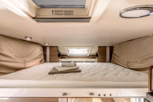 Cozy RV rental sleeping area with a large, comfortable mattress, overhead lights, and a window for natural light.. Wallace Wallace 2020