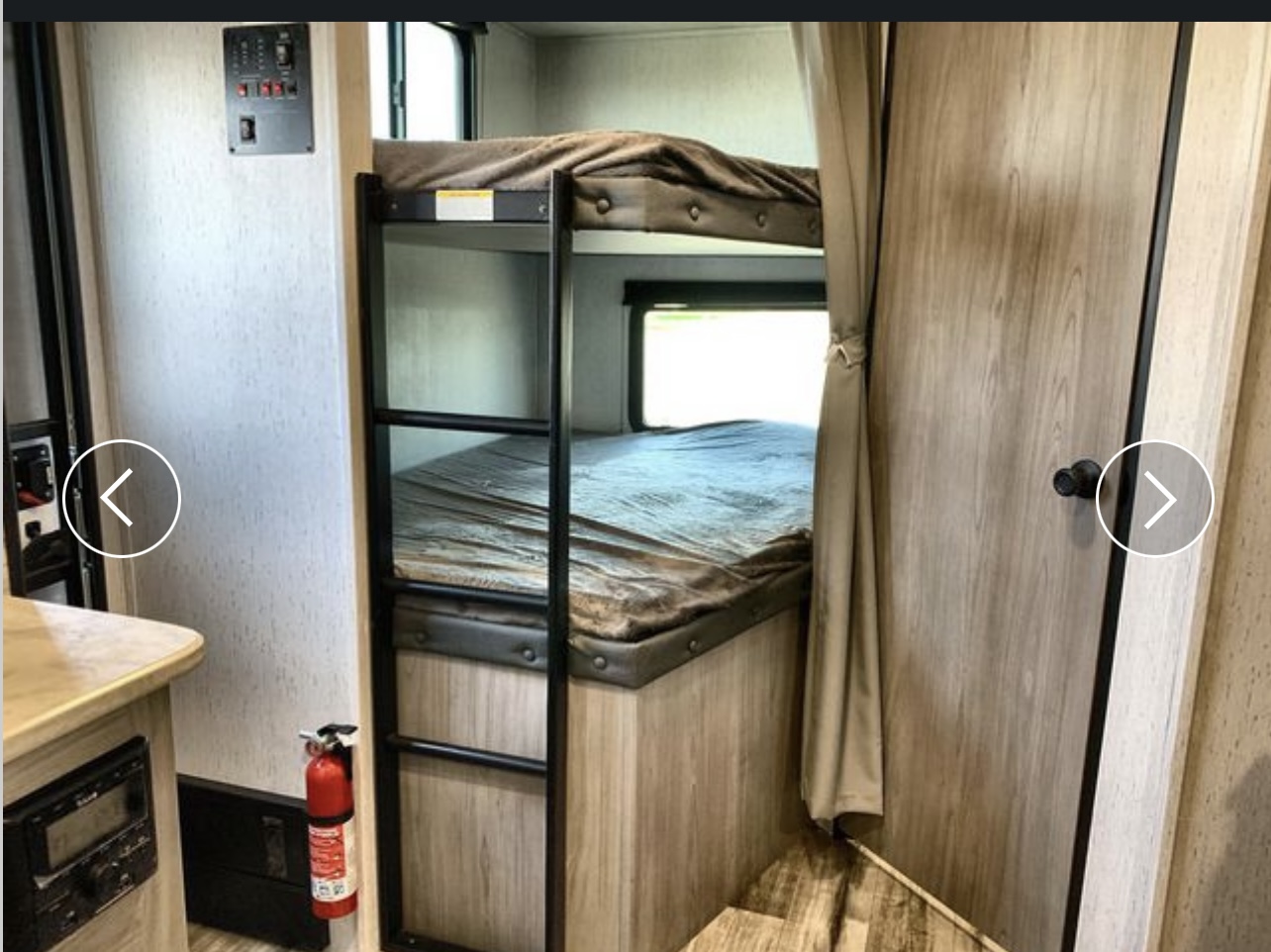 RV rental with a view of bunk beds inside, featuring a safety fire extinguisher and a control panel for your convenience.. Coleman Lantern 2022