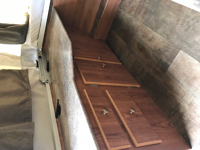 This RV rental interior features a pop-up bed, under-bed storage with wood-look panels, and wood-grain flooring.. Forest River Other 2017