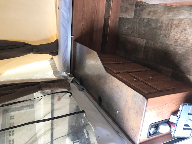 This RV rental interior features a cozy pop-up bed area on the left and practical built-in storage cabinetry on the right.. Forest River Other 2017