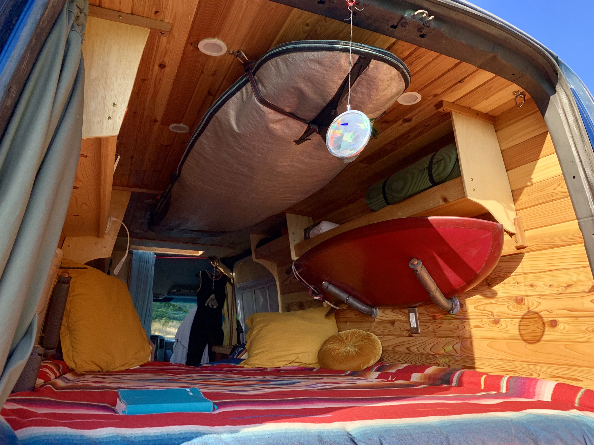 This RV rental features a cozy, custom wood interior with a comfy bed, overhead surfboard, and red kayak storage. Ideal for adventurers.. Freightliner Sprinter 2007