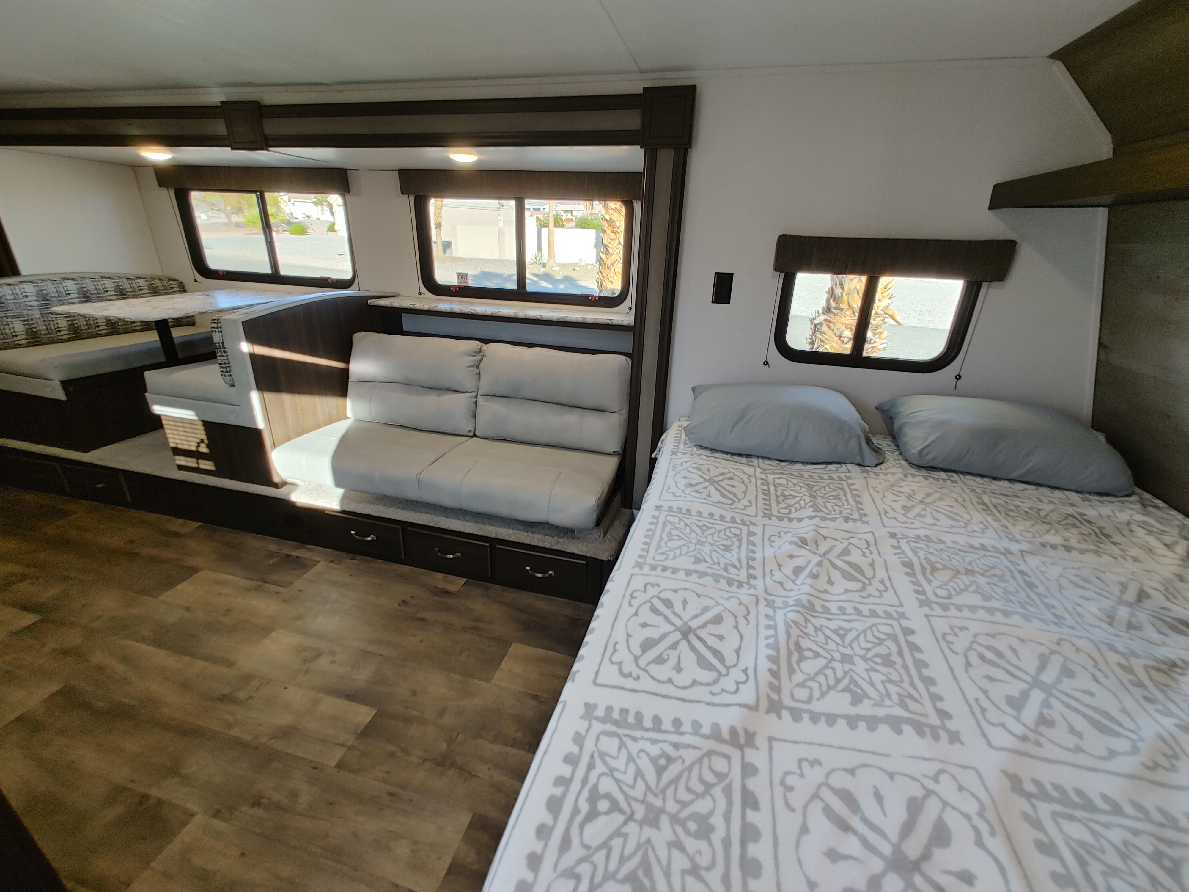 Spacious RV rental interior with bedroom, sofa, and dinette area, perfect for travel.. Keystone RV Springdale 2020