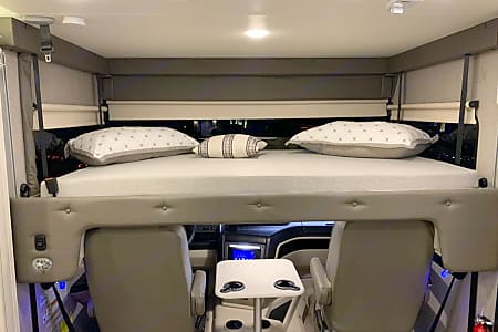 RV rental's spacious overhead bunk bed with pillows provides extra sleeping space above the cab cockpit.. Entegra Coach Vision 2022