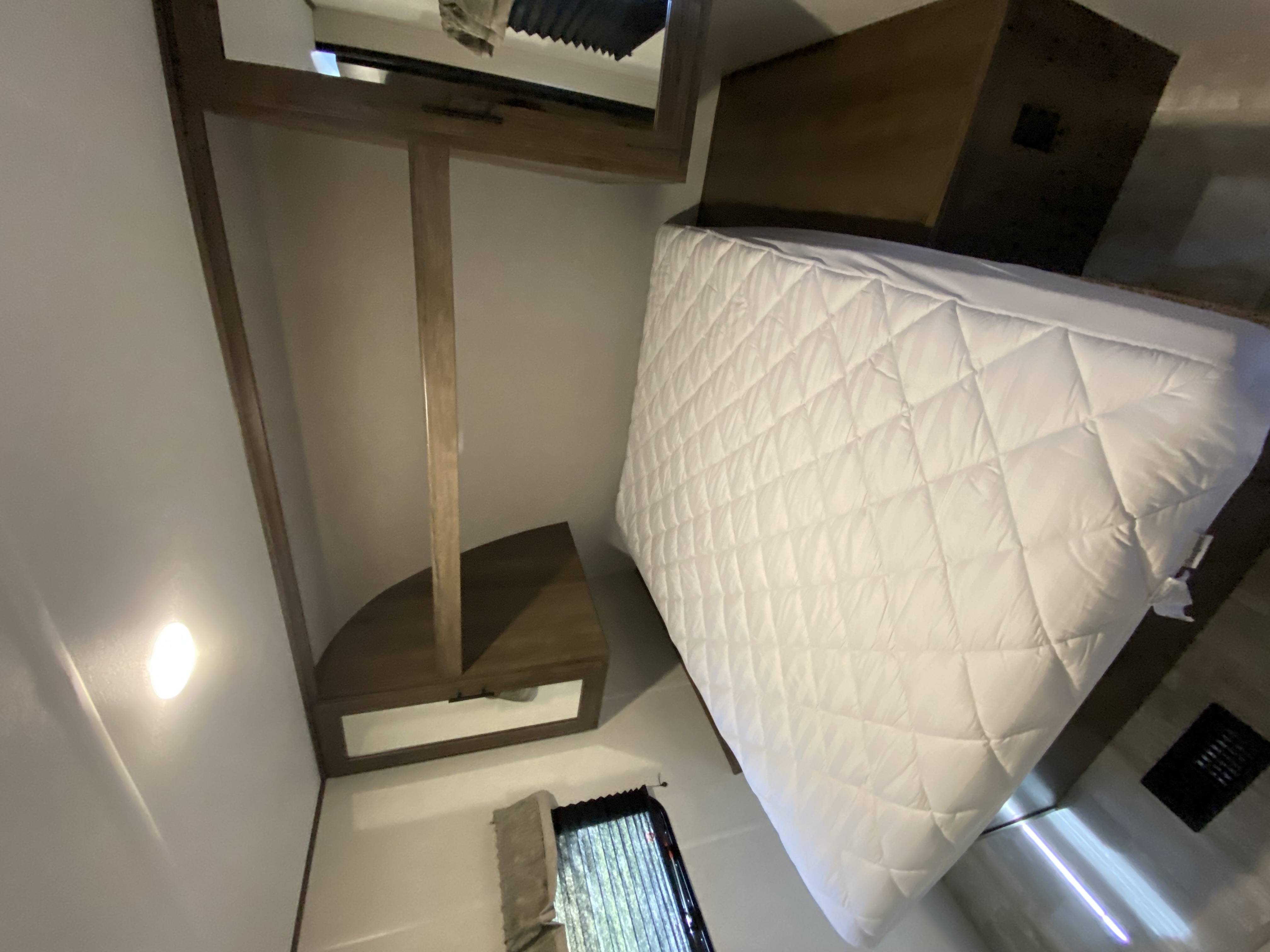 Cozy RV rental bedroom interior with a white bed, built-in cabinet, and compact layout, perfect for travel.. Avenger LE 2021