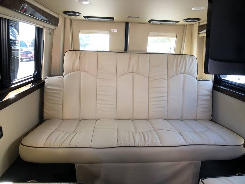 This RV rental features a spacious, cream-colored sofa, perfect for relaxing with large windows & TV.. American Coach Patriot 2022