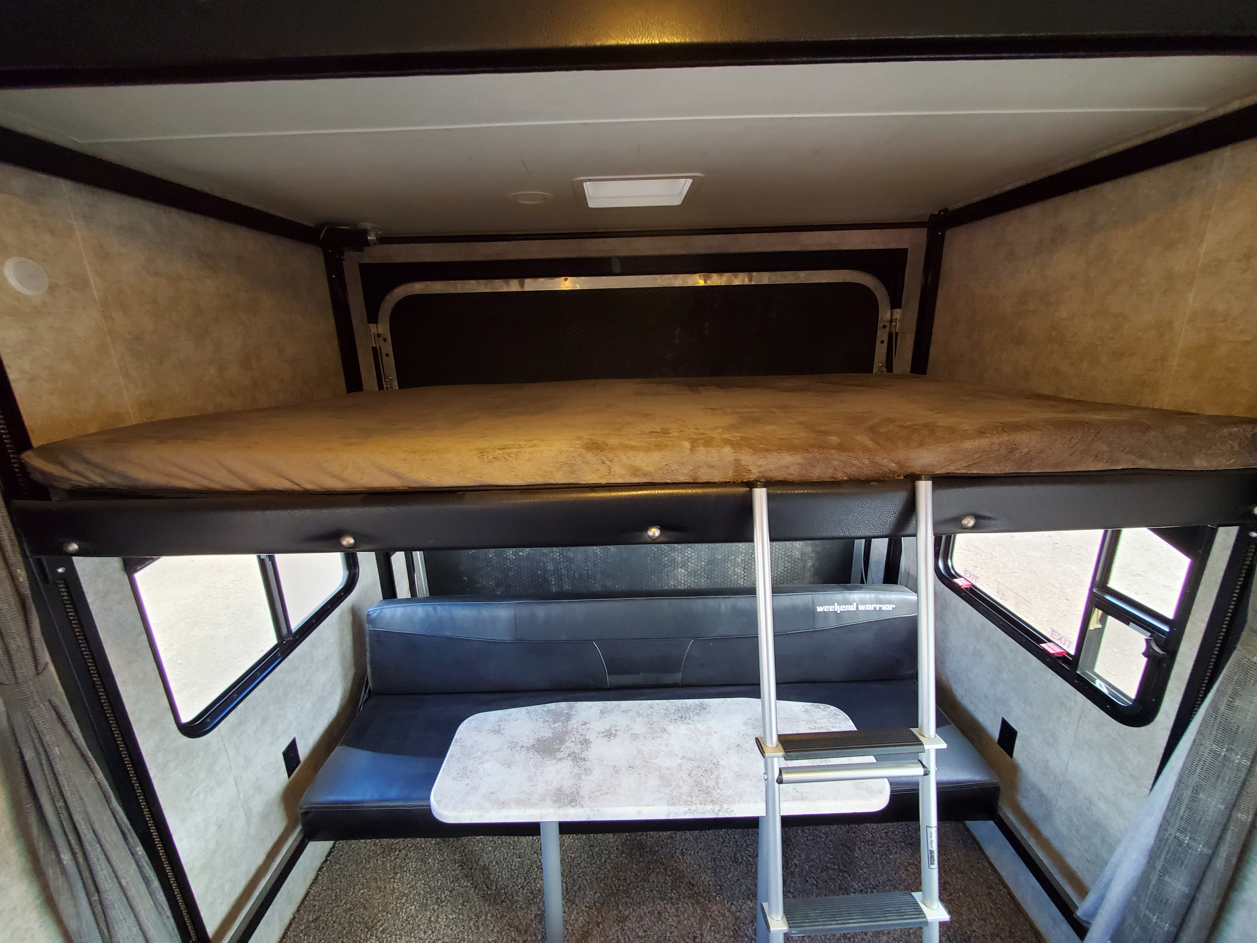 Explore this RV rental's versatile interior featuring a top bunk bed, lower dinette with seating, and table for relaxation.. Weekend Warrior jj2400 2019
