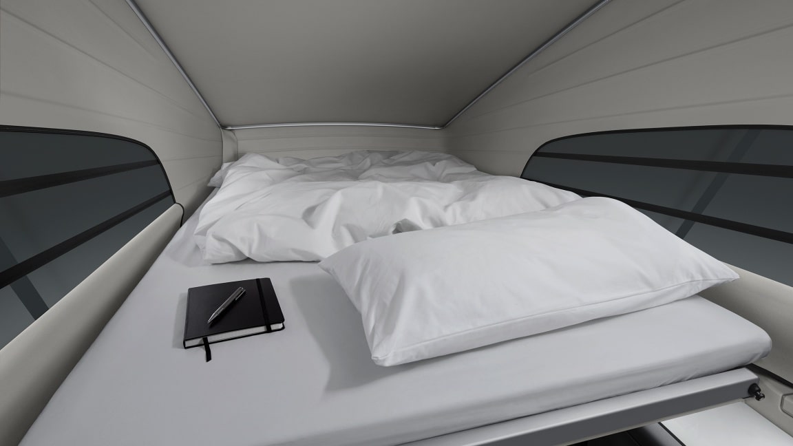 Spacious bed with white linens, pillow, and notebook in a modern RV rental. Enjoy comfortable sleeping on your travels.. Mercedes Marco Polo 2022
