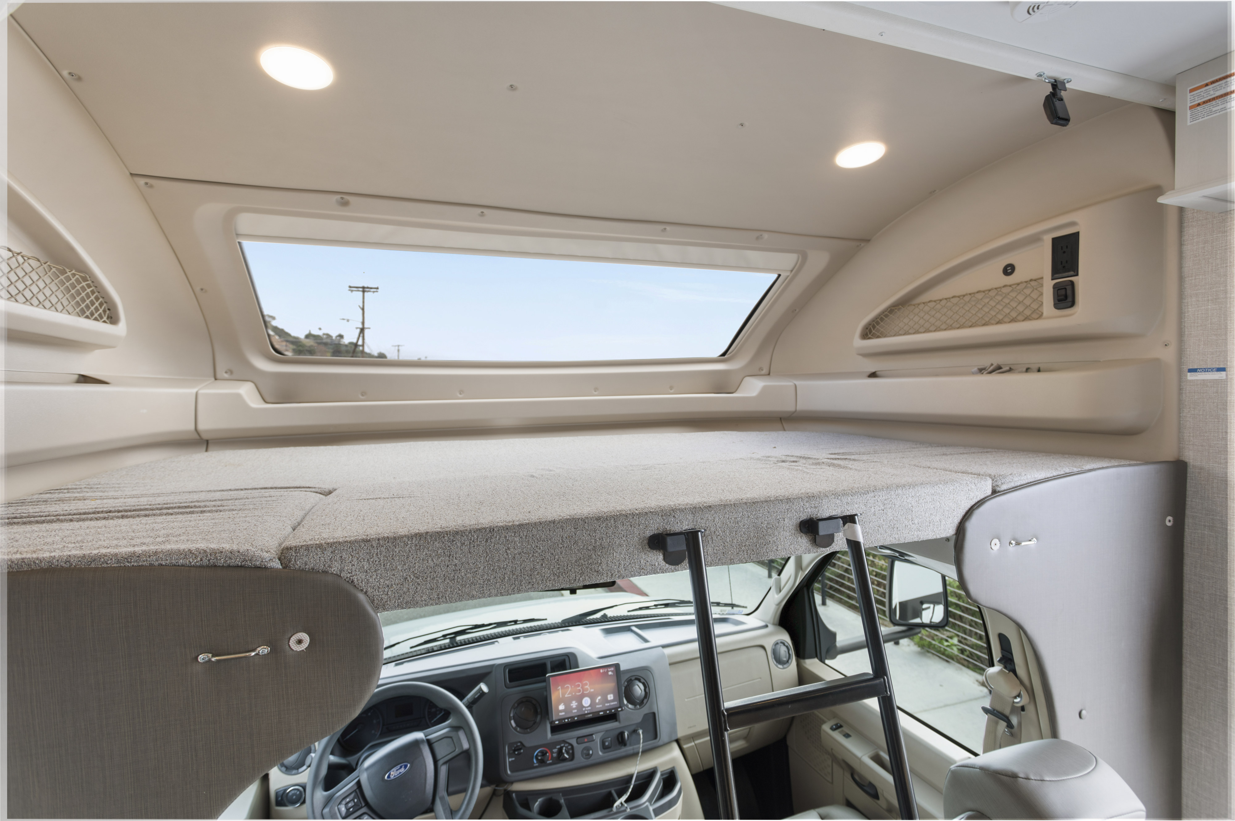 Spacious RV rental interior with a cab-over bunk bed, access ladder, and a large skylight. Shows the Ford dashboard below.. Other Other 2022
