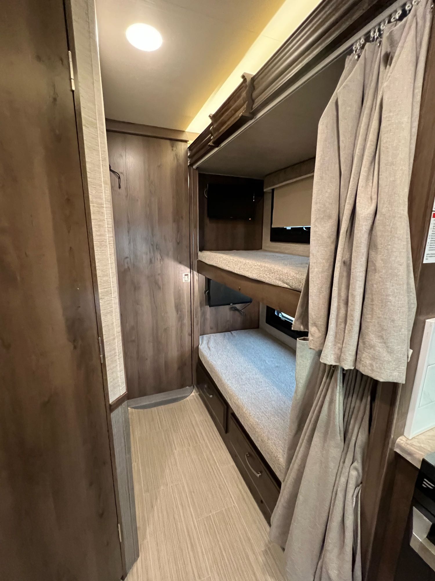 RV rental interior: two bunk beds with individual TVs and privacy curtains, perfect for family adventures.. Entegra Coach Vision 2021