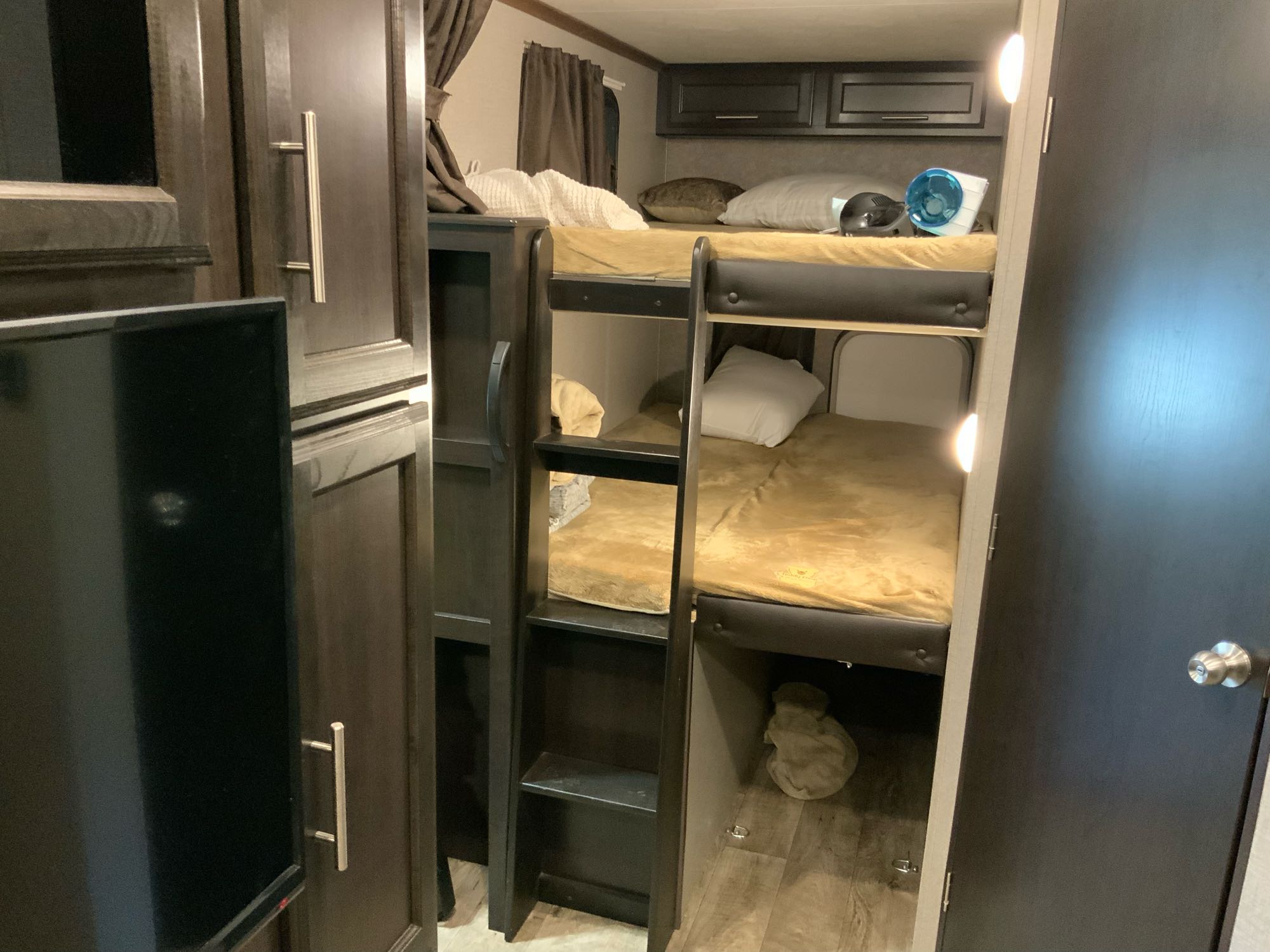 Inside this modern RV rental, find a comfortable bunk bed setup with two beds, integrated storage, and a private door. Ideal for travel.. Jayco Eagle HT 2019