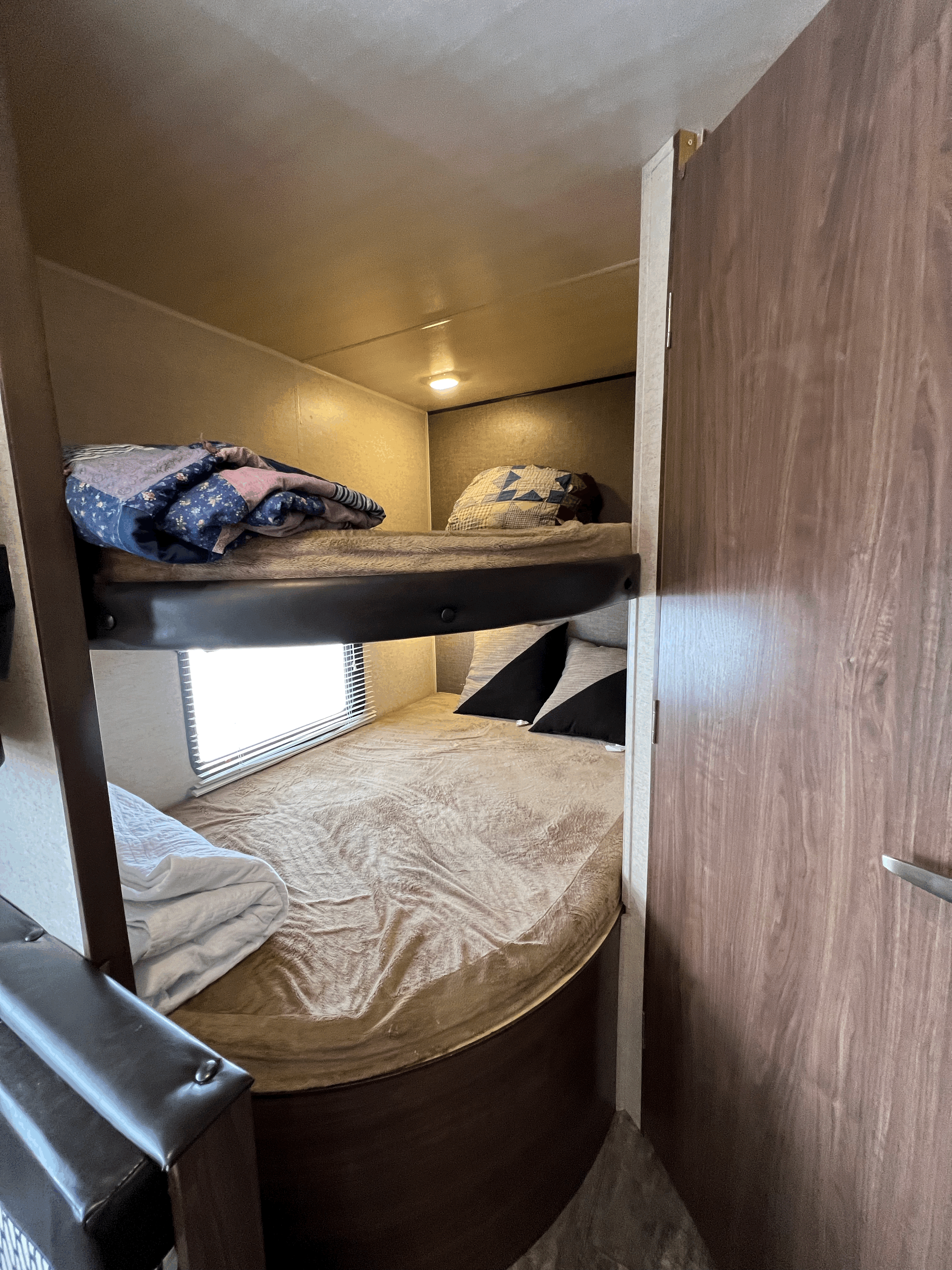 RV rental bunk beds: upper bed with quilt, lower with pillows, and window for cozy sleeping.. Heartland RVs Trail Runner SLE 2017
