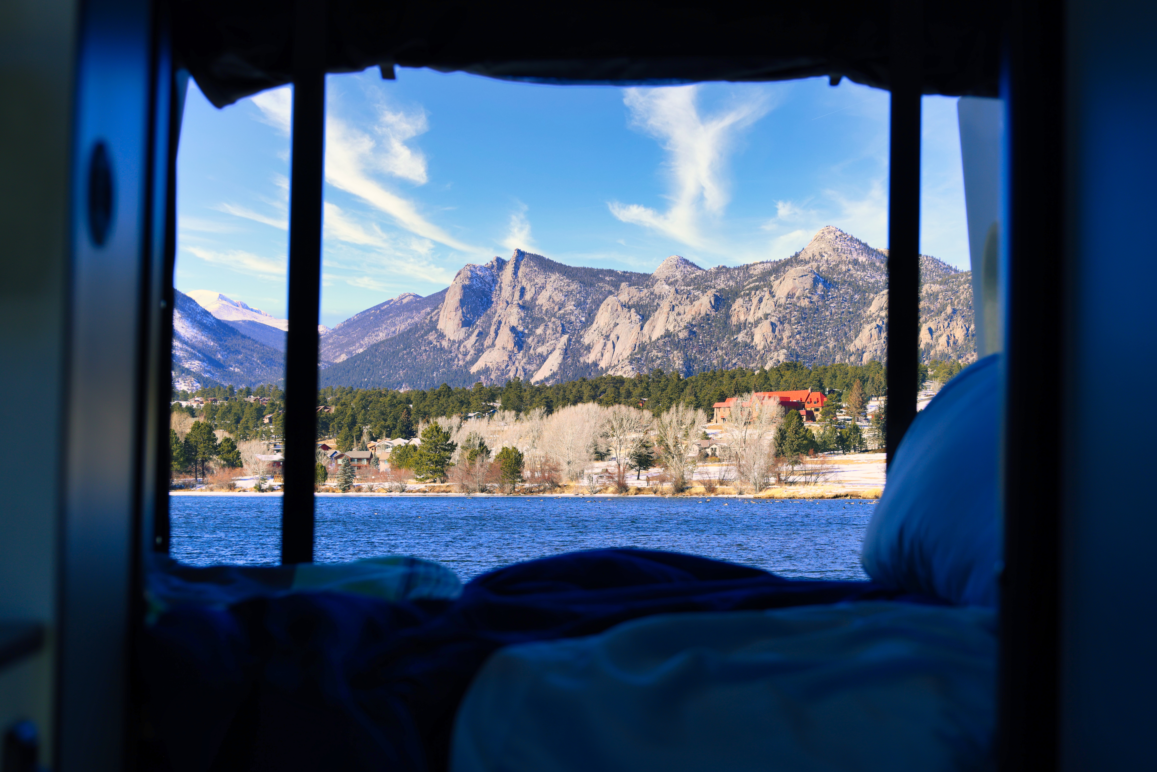 Wake up to stunning Rocky Mountain views from your RV rental! Lake and snow-dusted peaks framed by your cozy mobile home.. Winnebago Revel 2022