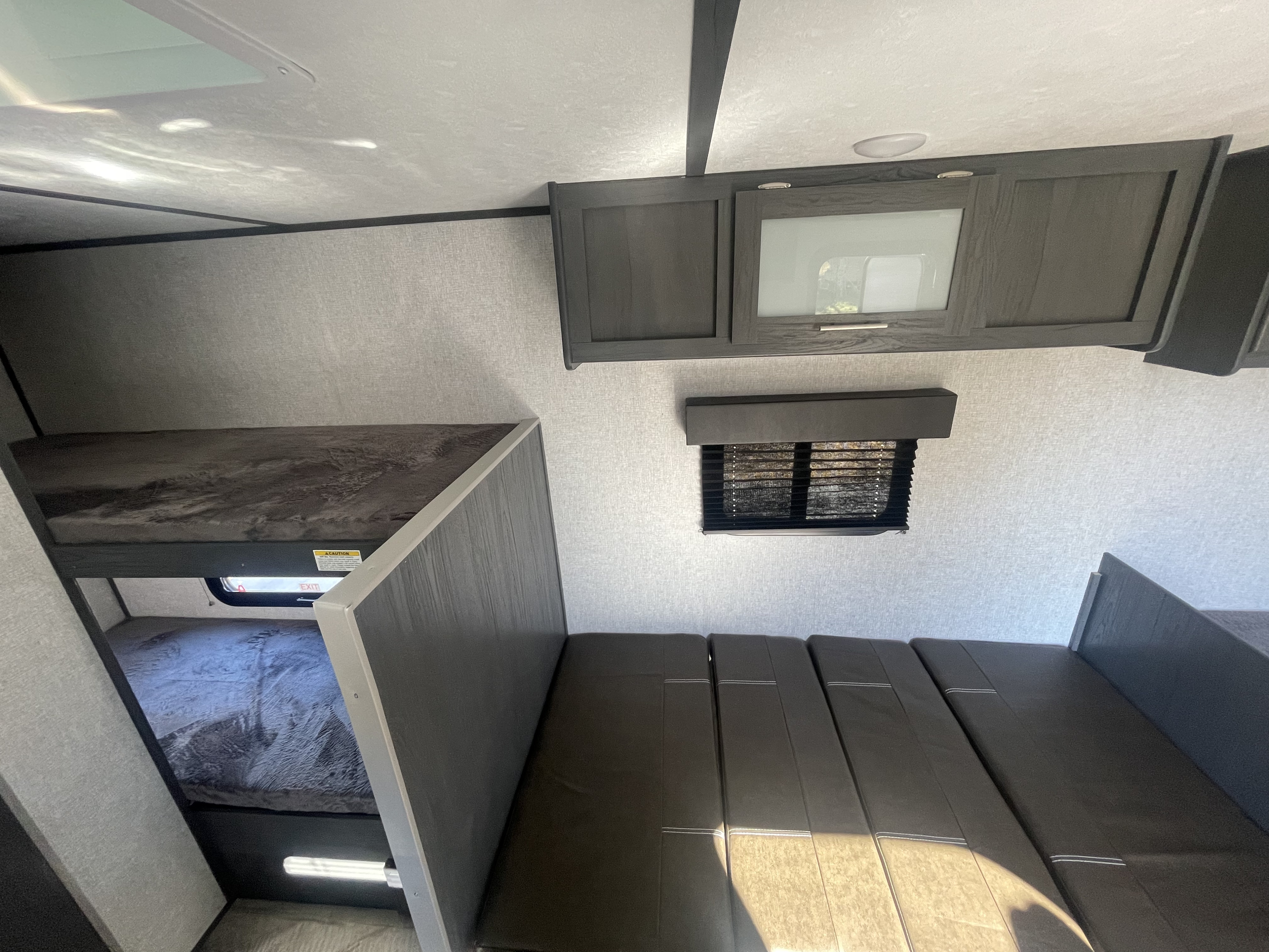 Modern RV rental interior with cozy bunk beds, comfortable seating, overhead storage, and a window for family adventures.. Dutchmen Rv Aspen Trail 17BH 2022