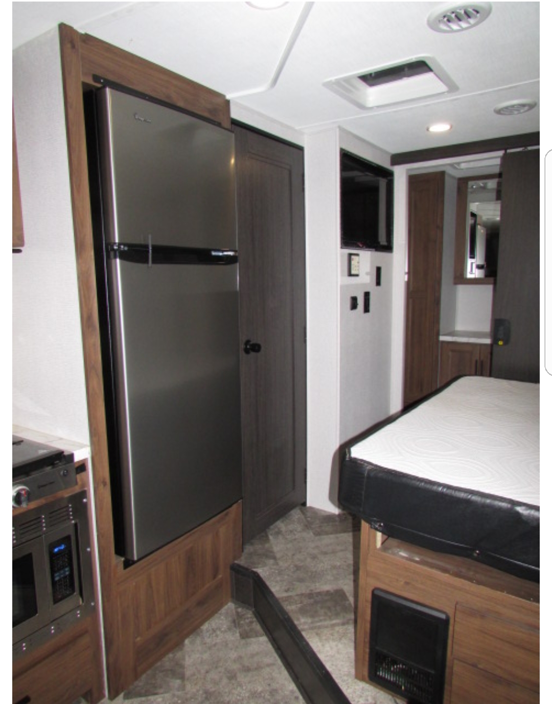 RV rental interior: full-size fridge, comfy bed, and compact kitchen. All essentials for your adventure.. Forest River Sunseeker 2020