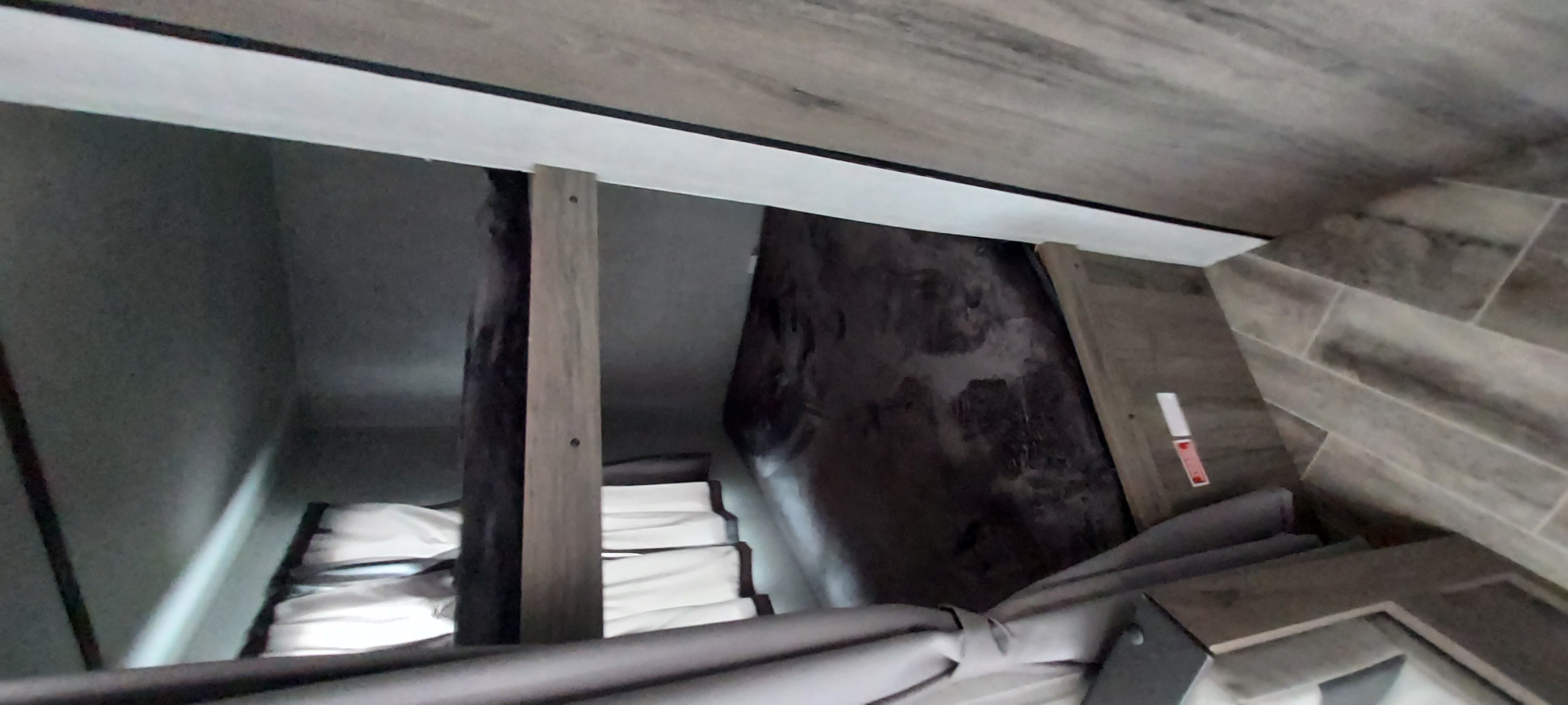 RV rental bunk bed sleeping area. Two stacked bunks with white mattresses in a clean, modern interior with wood accents.. Amerilite 197BH 2021