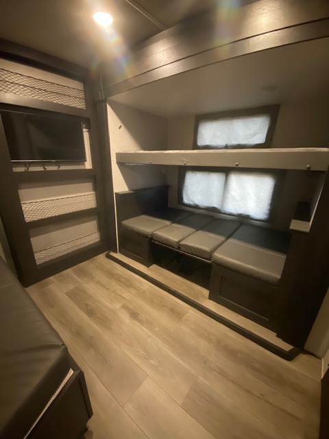 RV rental interior: cozy bunk beds, convertible dinette, & TV perfect for family trips.. Open Range Open Range 2021