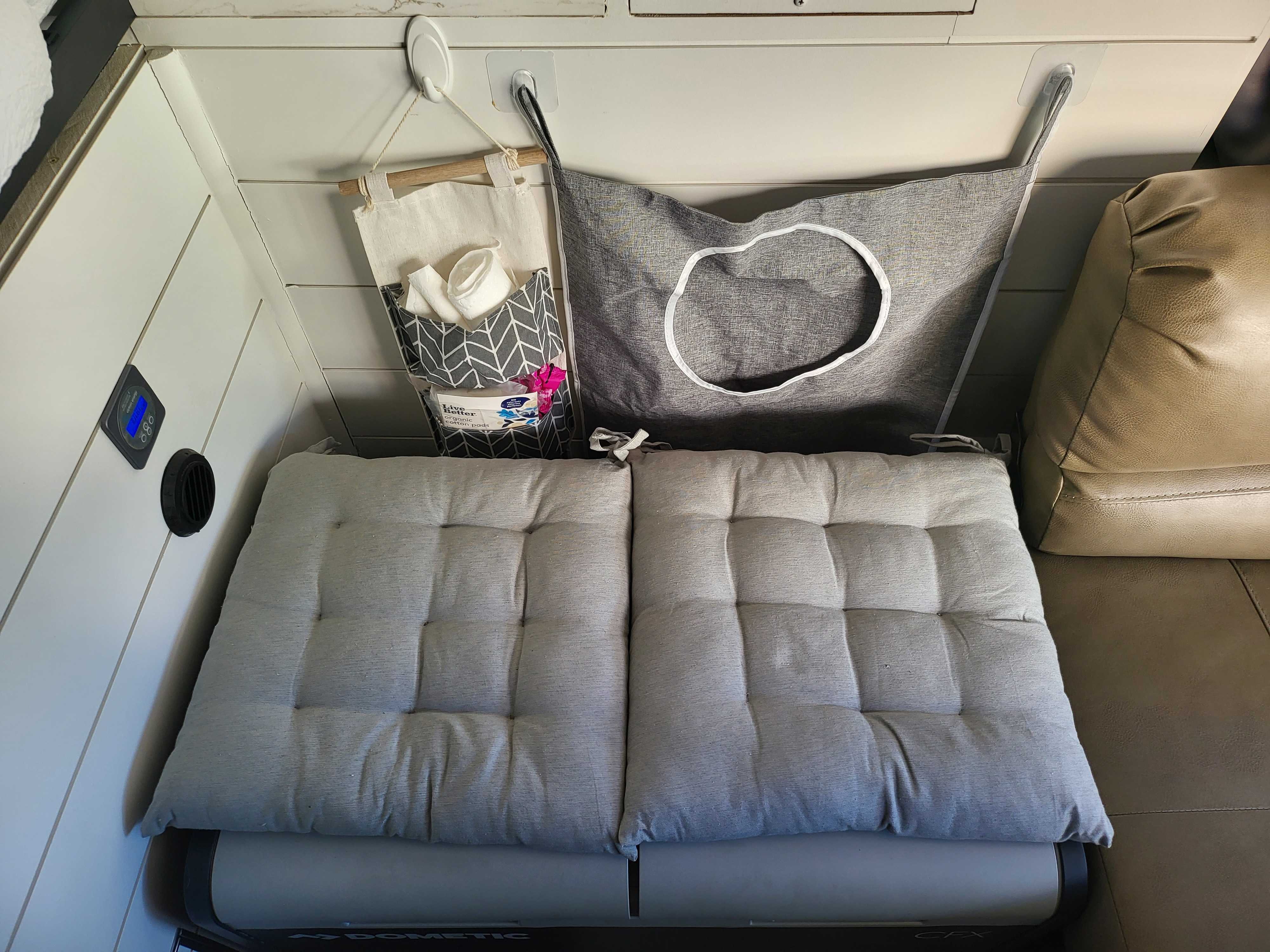 Cozy RV rental interior with Dometic cooler, comfy seating, and hanging organizers for essentials.. Ford Transit 2020