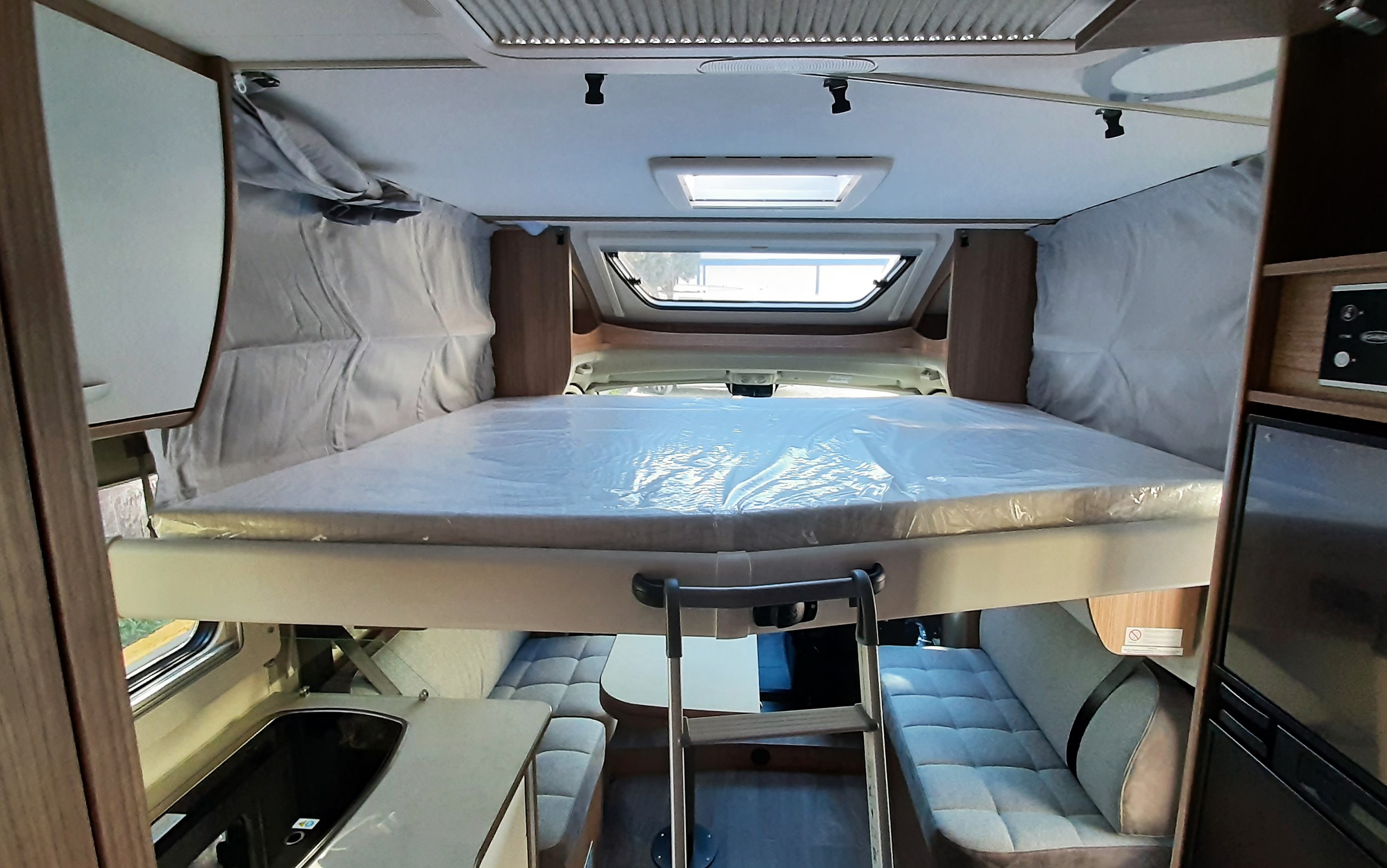 Experience comfort in this RV rental! Features an elevated bed, convertible dining area, and practical kitchen setup.. Carado T459 2022