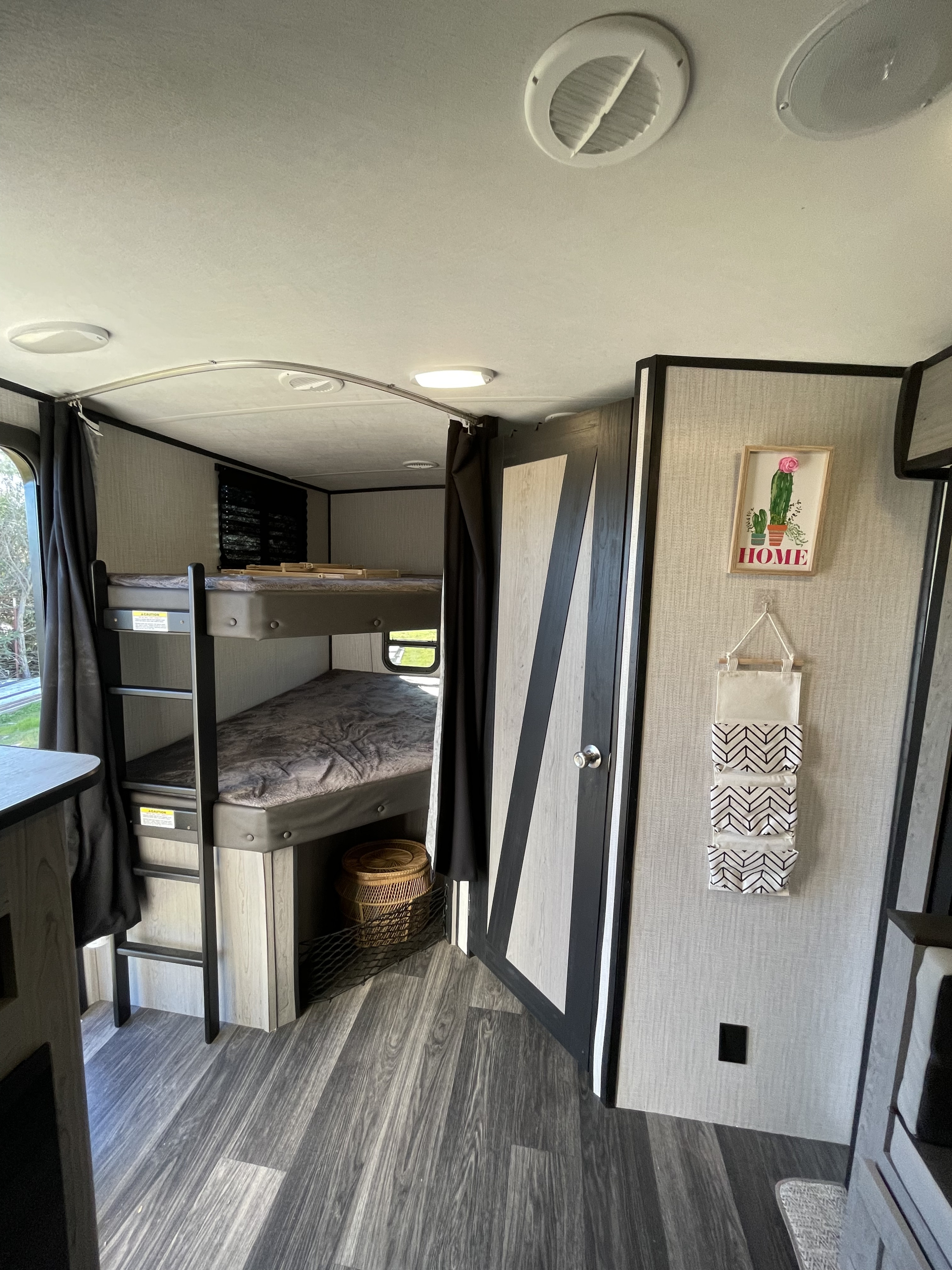 Cozy RV rental interior featuring bunk beds, a patterned door, and home decor, ideal for family adventures.. Heartland Mallard m251bh 2021