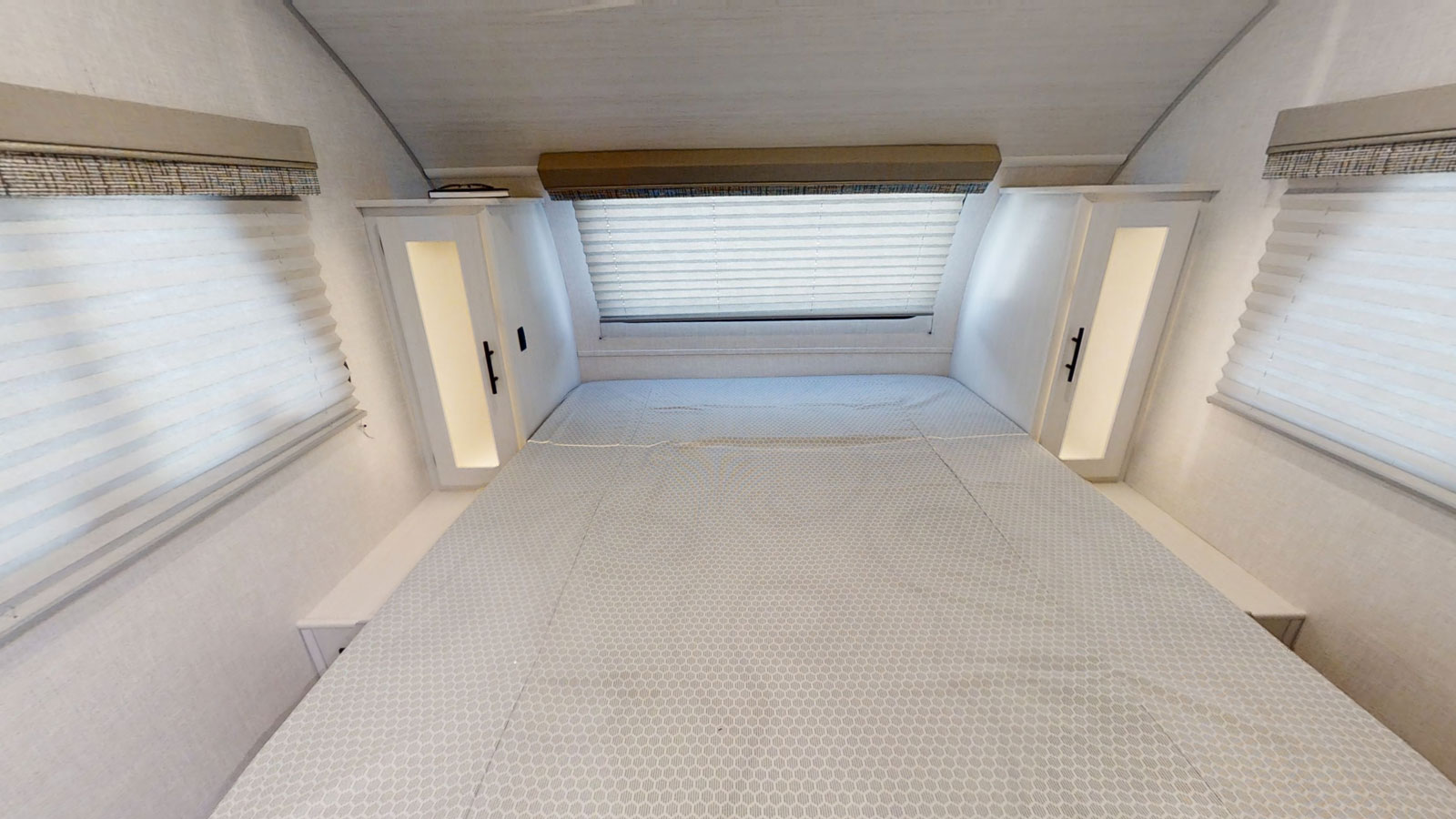 RV rental bedroom: a compact space with a comfortable bed, windows, and built-in storage.. Forest River R-Pod 2022