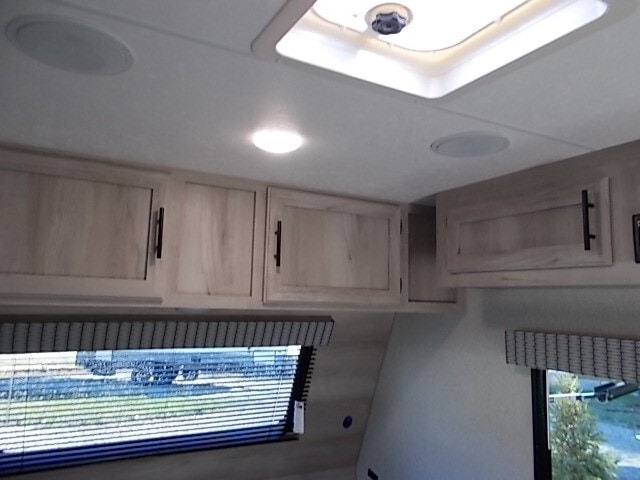 Inside your RV rental: bright, clean overhead cabinets, ceiling speakers, and a skylight creating a comfortable living space.. Sportsmen Classic 2022