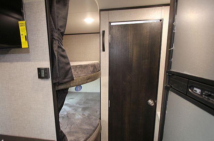 Spacious RV rental interior with bunk beds, TV, and fridge. Ideal for comfortable camper trips.. Jayco Jay Flight 2022