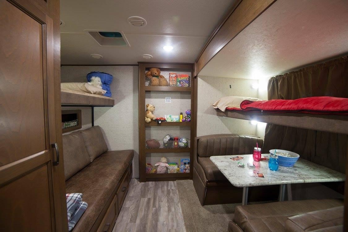Spacious RV rental bunkhouse interior. Features include multiple bunk beds, a dinette, and a comfy sofa. Ideal for families.. Other Light 2017