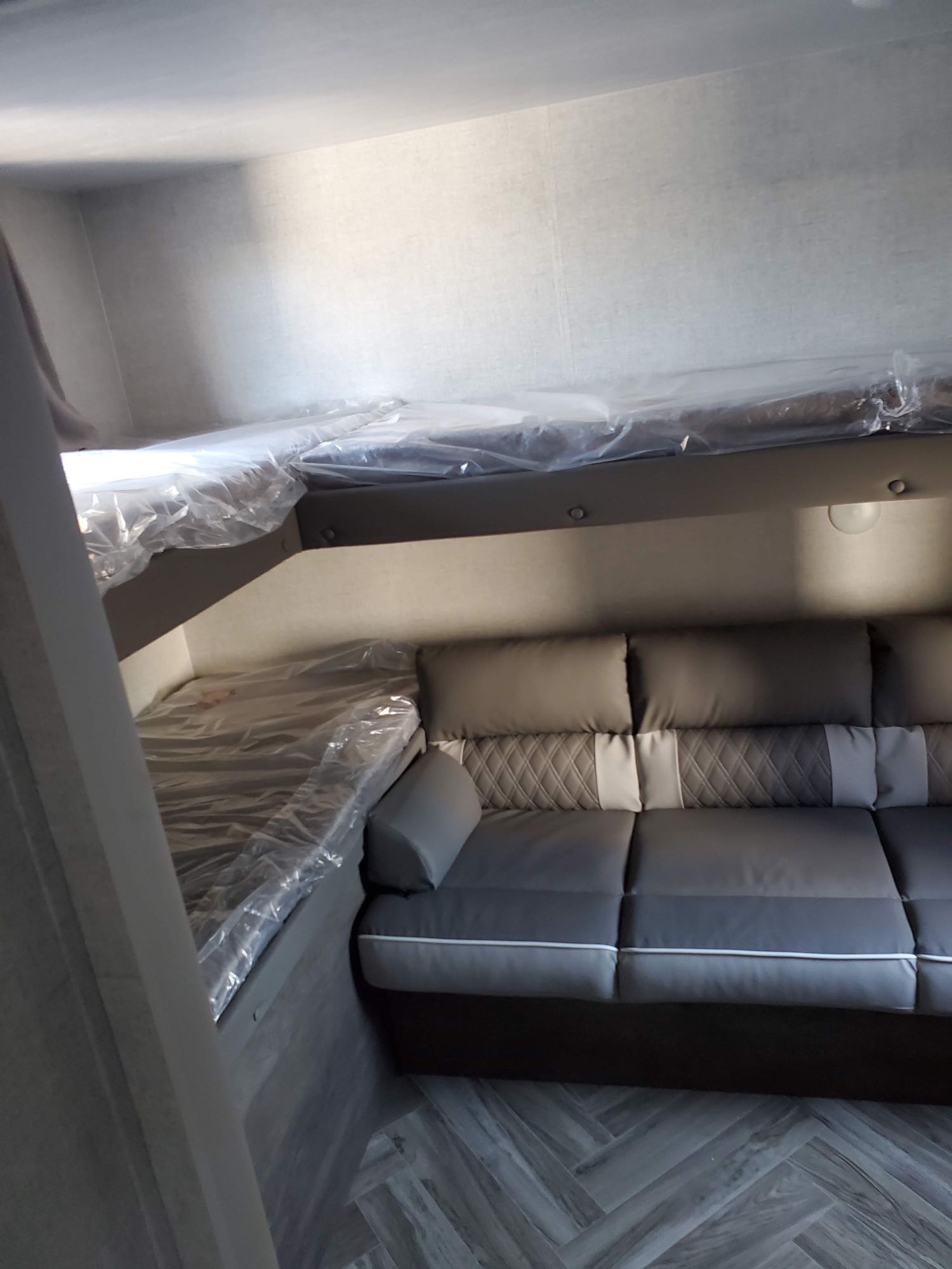 RV rental: modern interior with newly wrapped bunk beds and a comfortable sofa, ready for adventure.. Forest River Wildwood X-Lite 2021