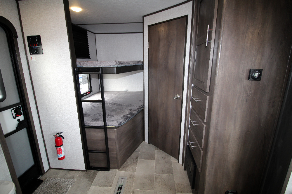 Spacious RV rental interior with comfortable bunk beds, intuitive control panel, and ample storage for a family trip.. Dutchmen Coleman 2022