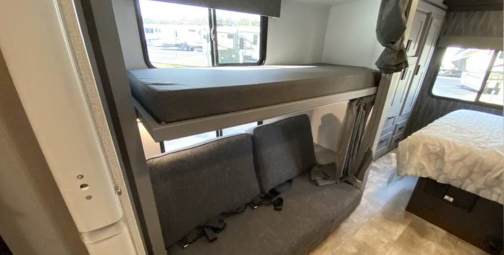 **RV rental** interior: bunk beds, a sofa with seatbelts, master bed, and storage offer comfortable family travel.. Forest River Solera 2022