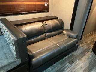 RV rental interior featuring a comfortable gray leather sofa and dinette seating, perfect for relaxing after a day of adventure.. Forest River Cherokee Grey Wolf 29VT 2015