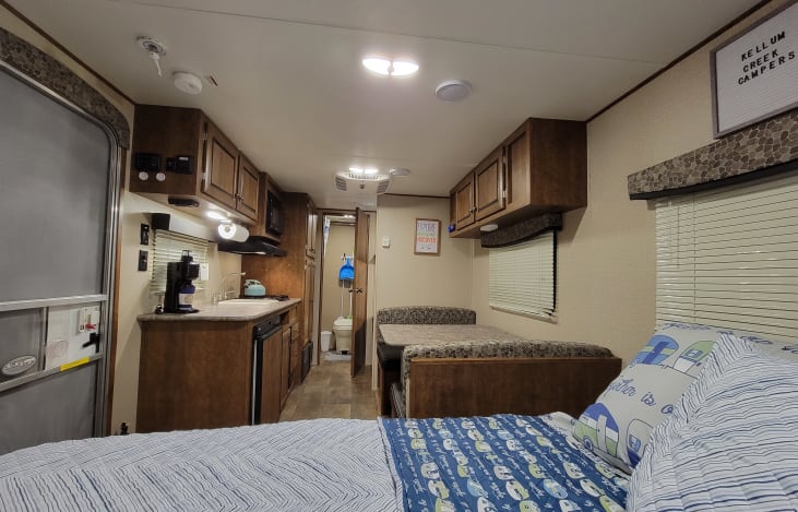 Cozy RV rental interior featuring a compact kitchen, dinette, and comfortable sleeping area, ideal for campers.. Crossroads RV Z-1 Lite 2017