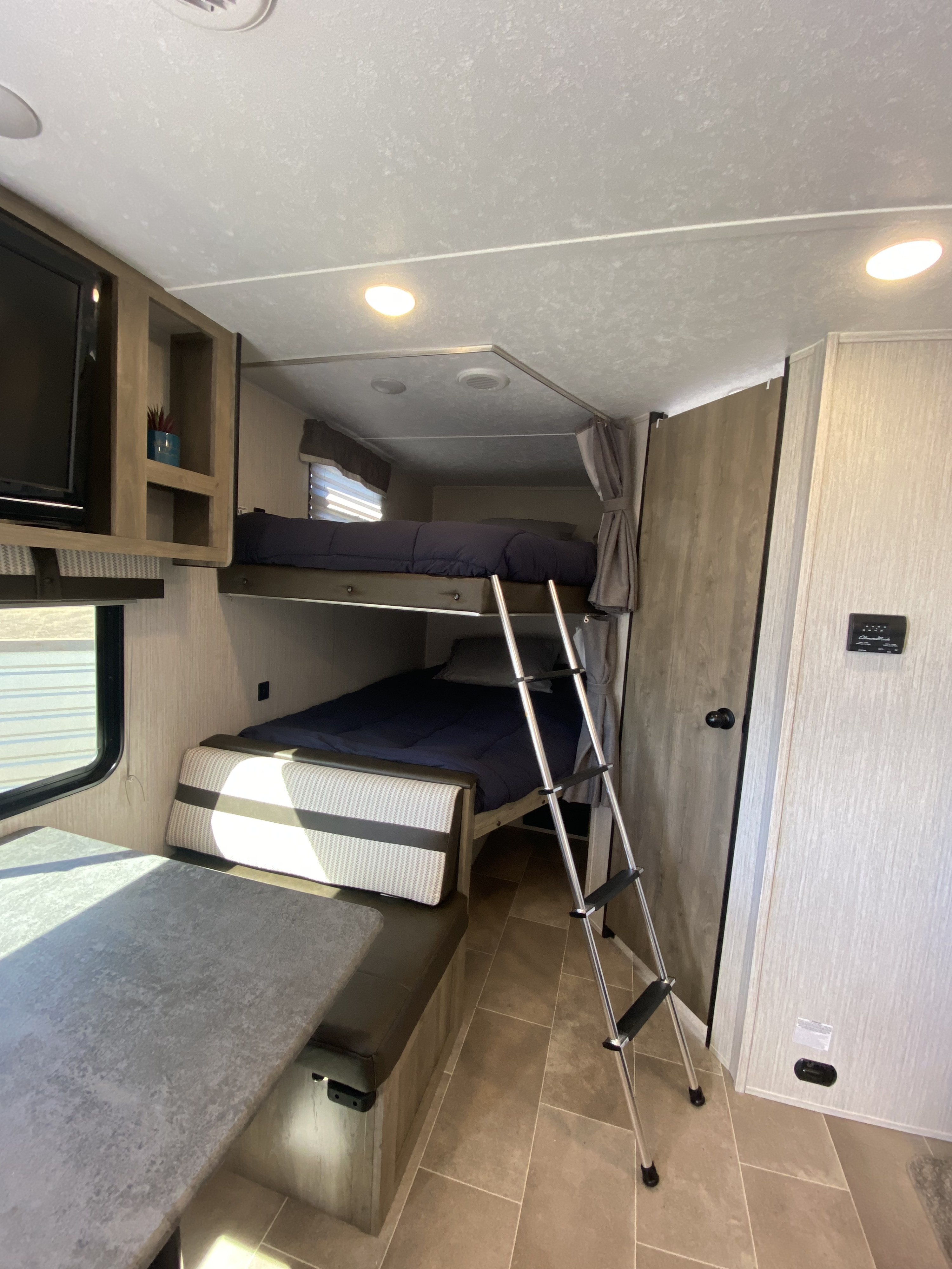 RV rental interior: cozy bunk beds, a ladder for access, and a comfortable dinette area for your adventures.. palomino puma xle 2021