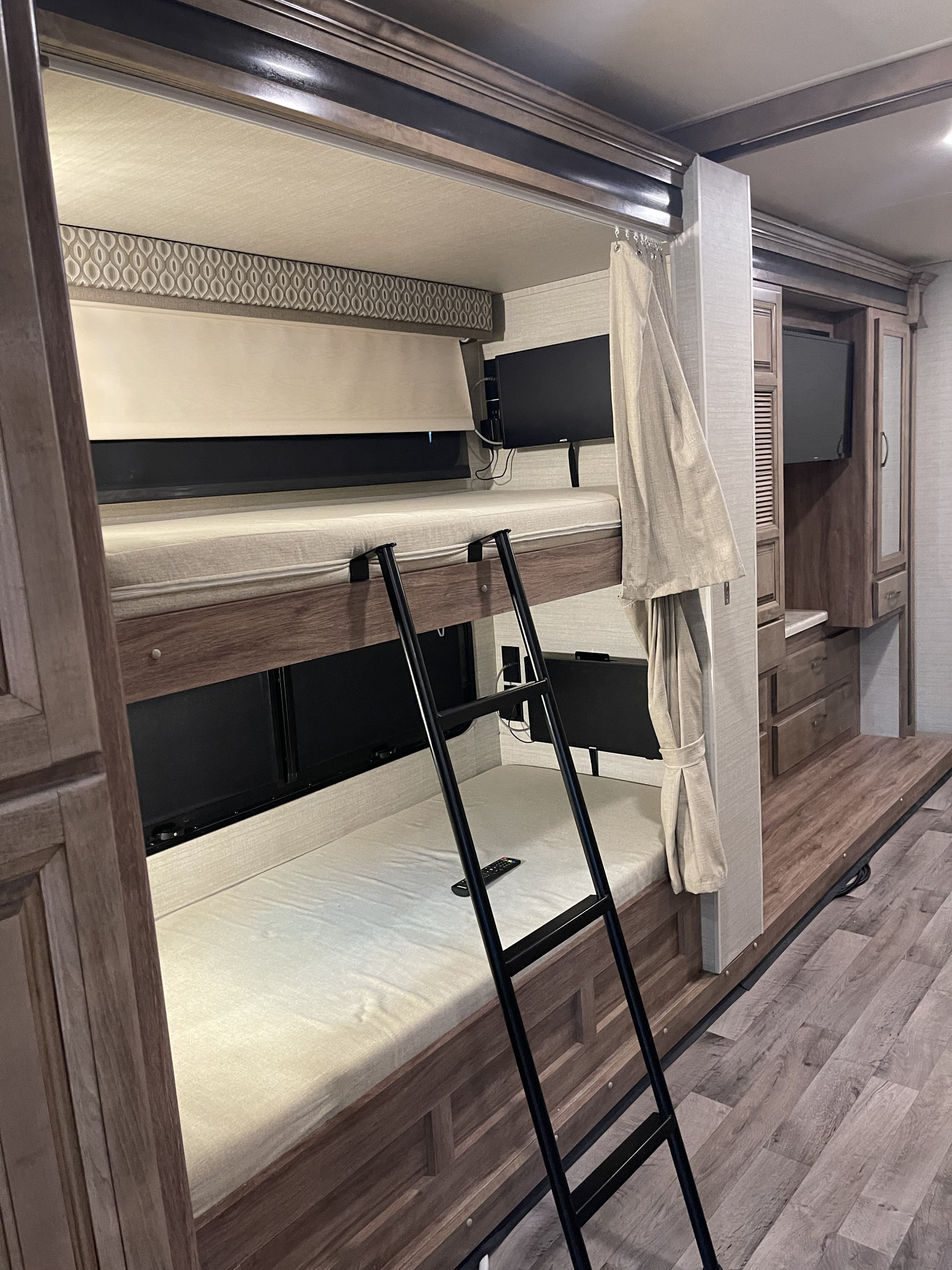 RV rental interior: cozy bunk beds with individual TVs, ladder, and privacy curtains.. Jayco Precept 2019