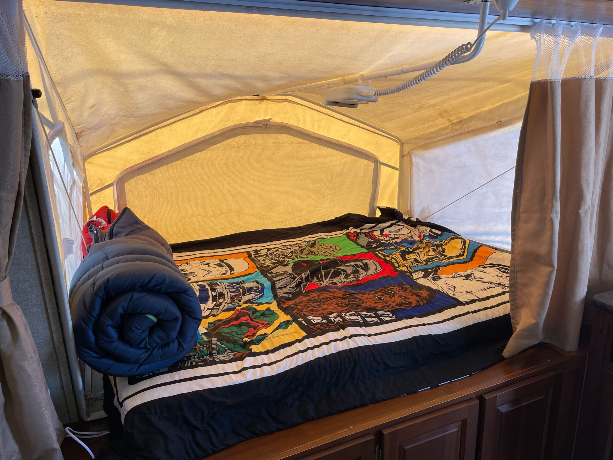 RV rental's cozy pop-up camper bed features a Star Wars comforter & sleeping bag, ideal for adventure.. Forest River Rockwood Roo 2014
