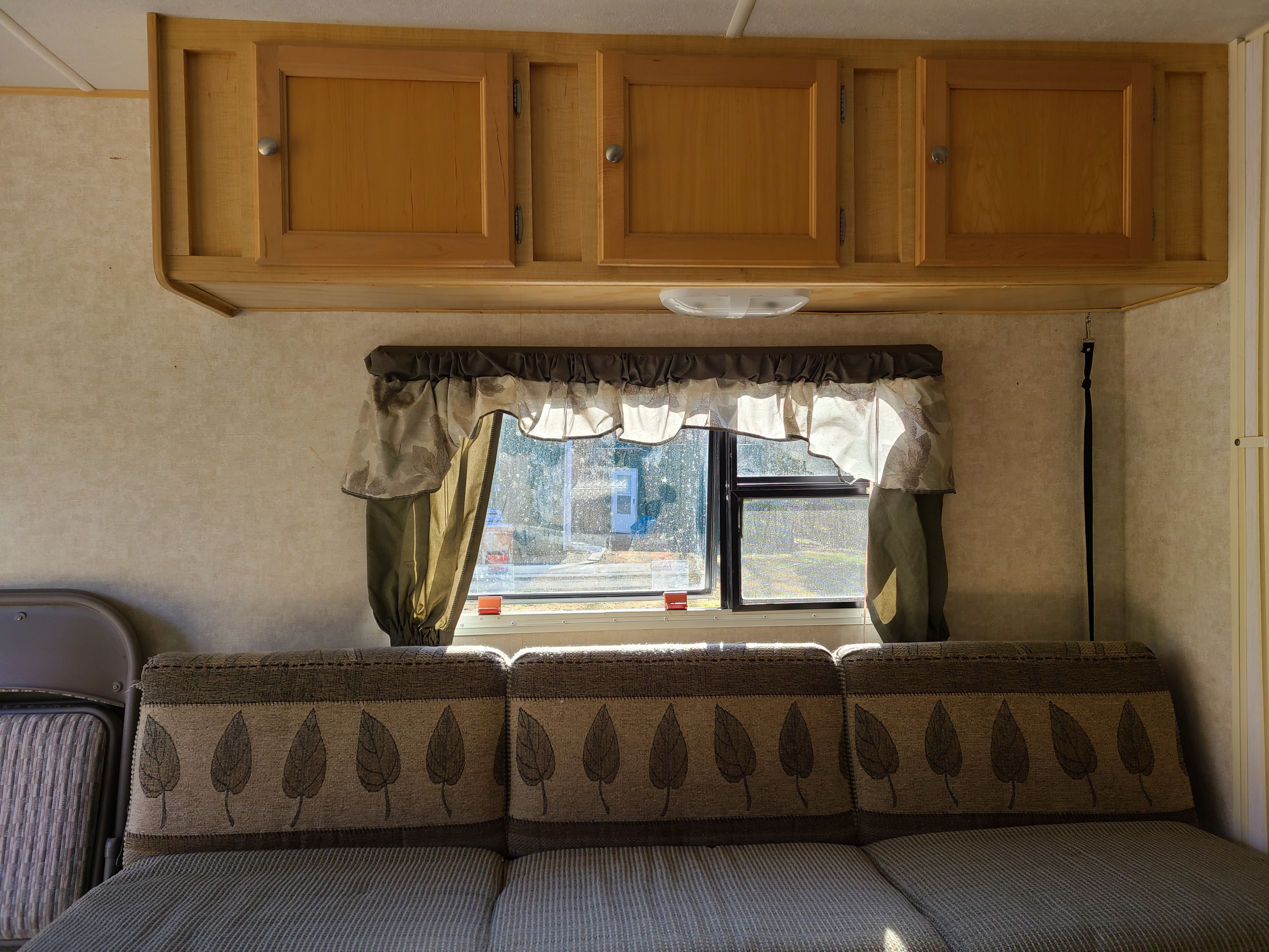Relax in this RV rental interior, featuring warm wood cabinets & a comfortable couch with a window view.. R-Vision R-Wagon 291rw 2006