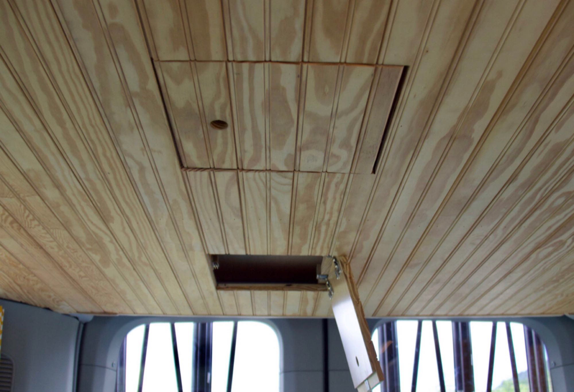 RV rental wooden ceiling with an open access hatch, revealing an internal compartment.. Ford Transit 2016