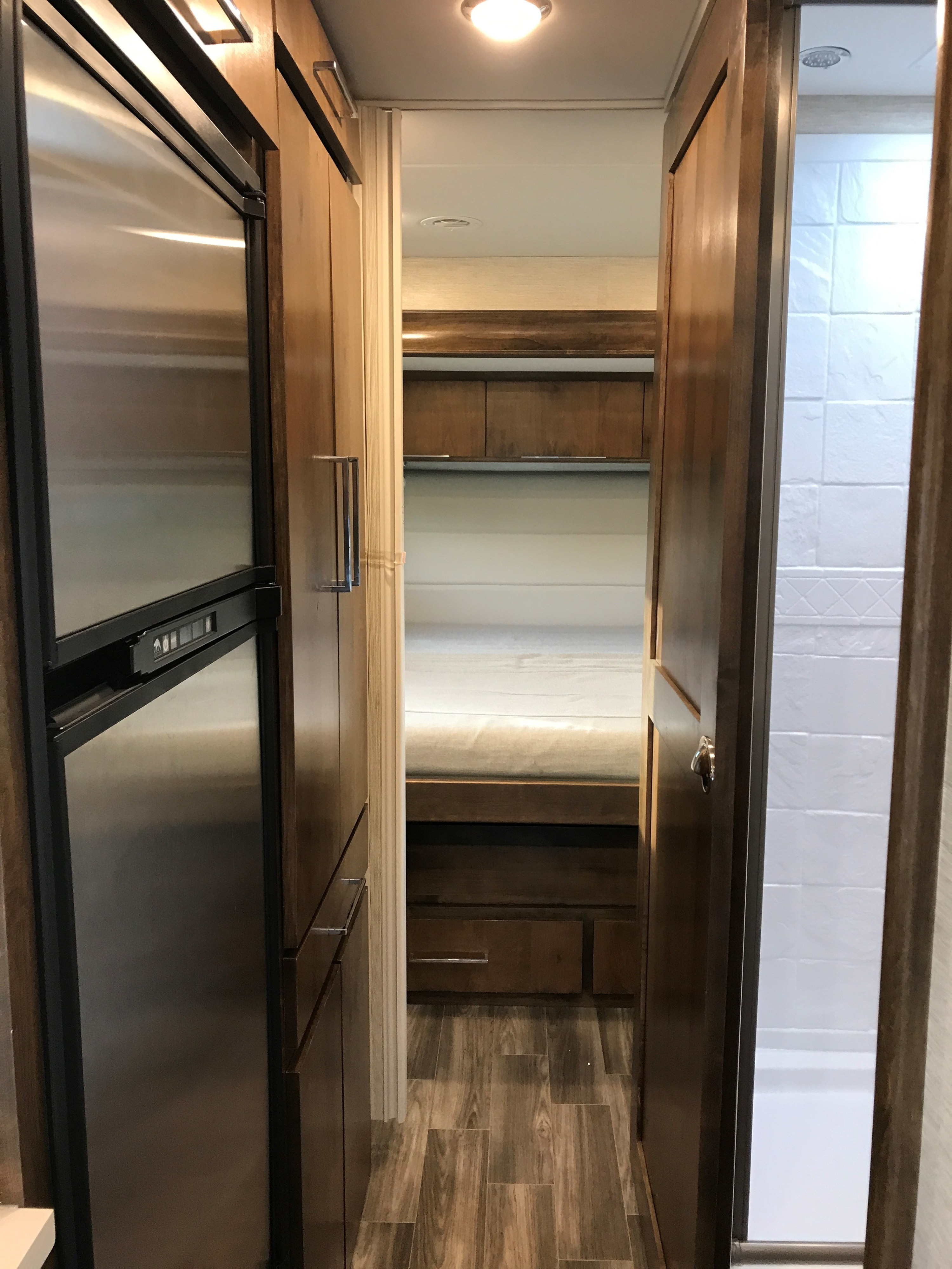RV rental interior showing a hallway with a stainless steel refrigerator, bunk beds, and a bathroom.. Wayfarer Wayfarer Motorhome 2020