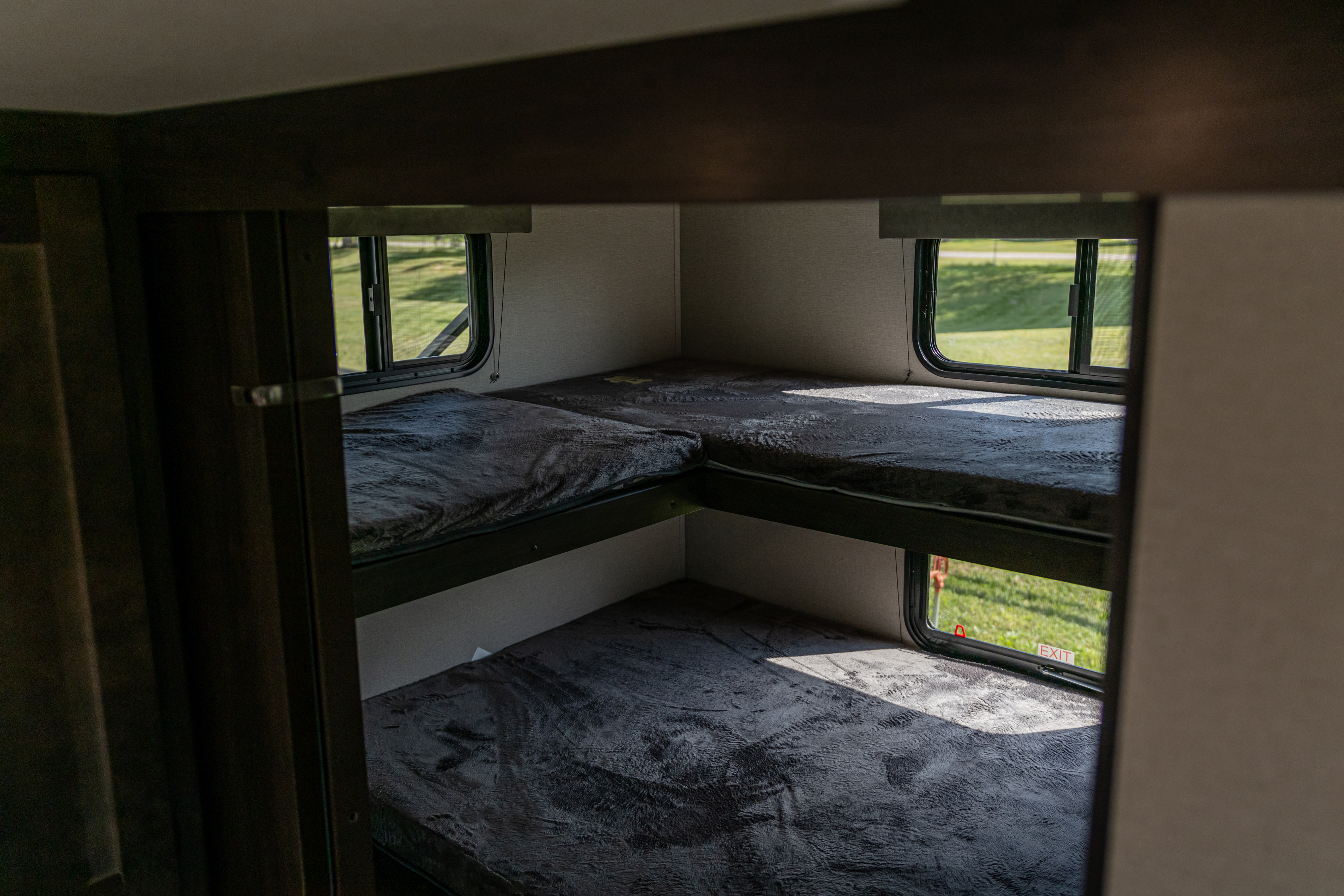 Cozy RV rental interior with comfortable bunk beds featuring soft blankets and windows to the outdoors.. Grand Design Other 2022