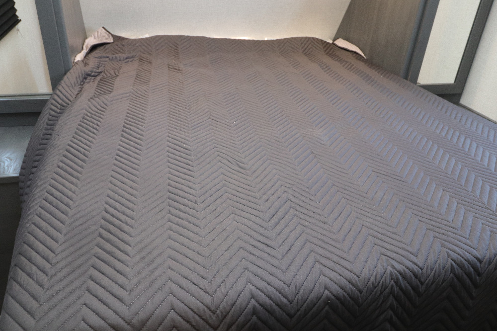 Cozy RV rental bed featuring a grey chevron quilted comforter, perfect for your next adventure.. Duchmen Aspen trail 2850BHS 2022
