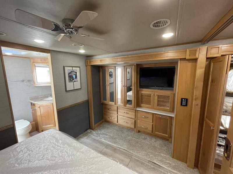 This bright RV rental bedroom features a comfy bed, integrated TV and cabinetry, plus an attached bathroom for ultimate comfort.. Allegro Allegro Open Road 2022