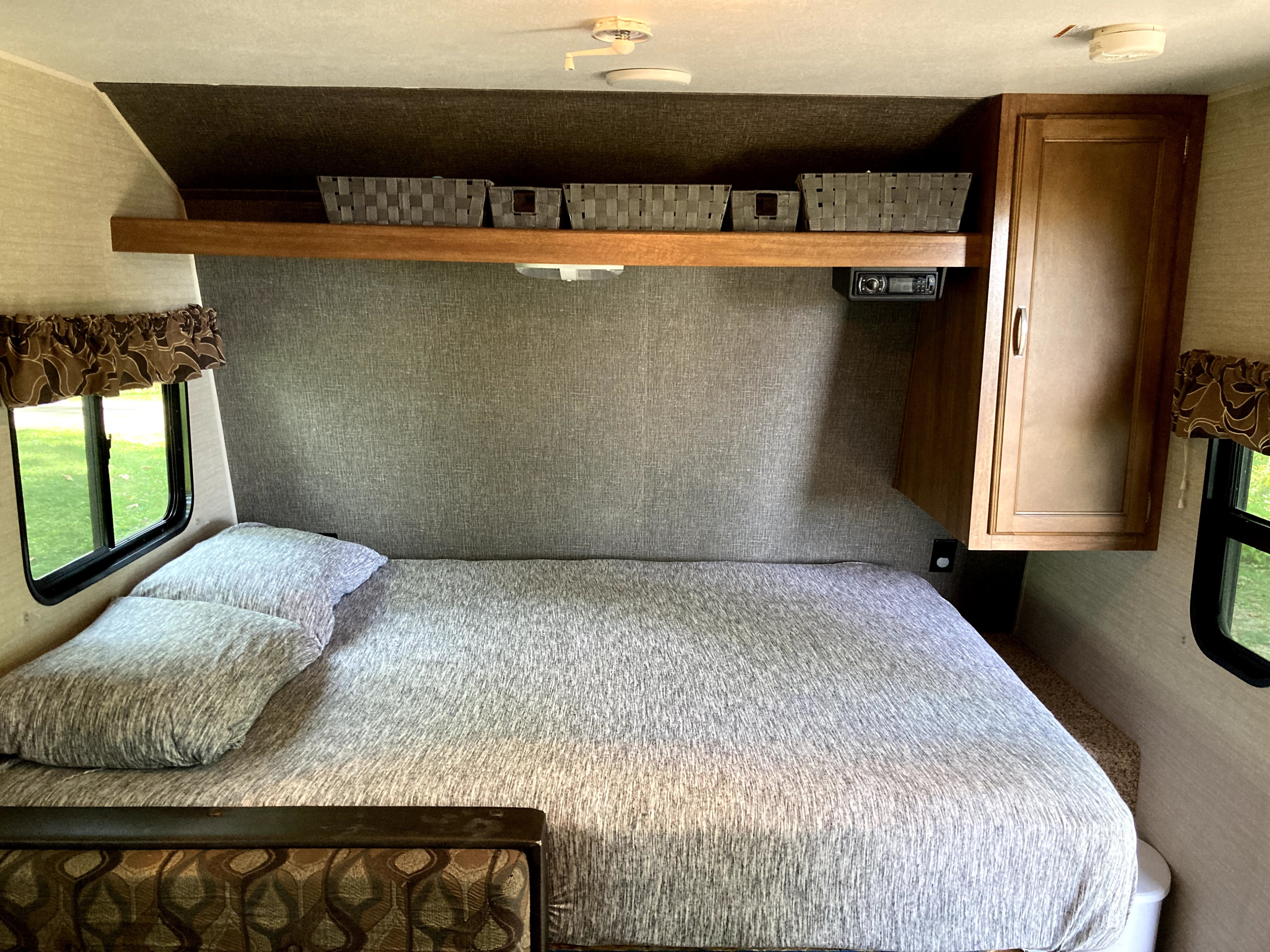 Cozy RV rental bedroom featuring a comfortable bed, overhead storage, and entertainment for your travels.. Keystone RV Summerland Mini 2016