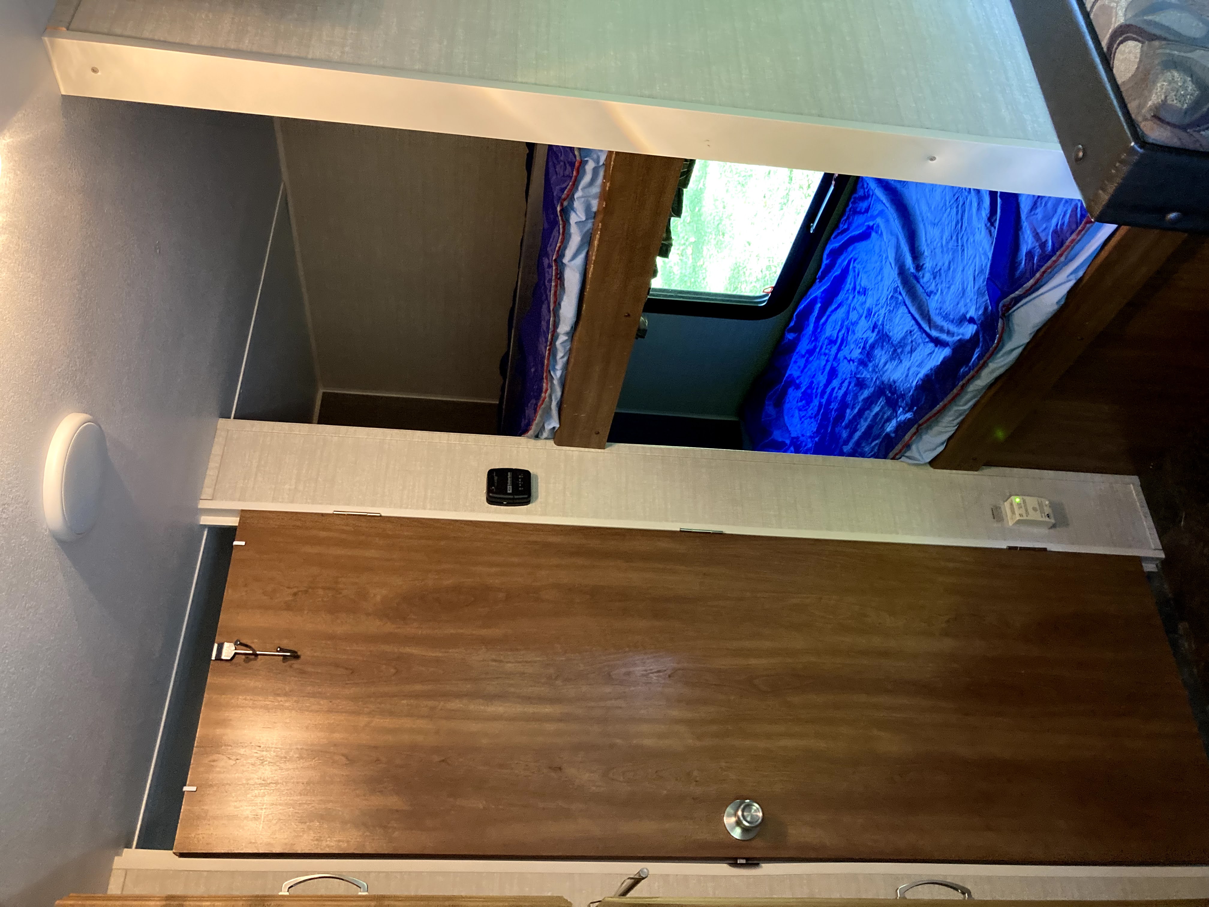 RV rental living space featuring a bunk bed, window view, and interior door with light and control panels.. Keystone RV Summerland Mini 2016