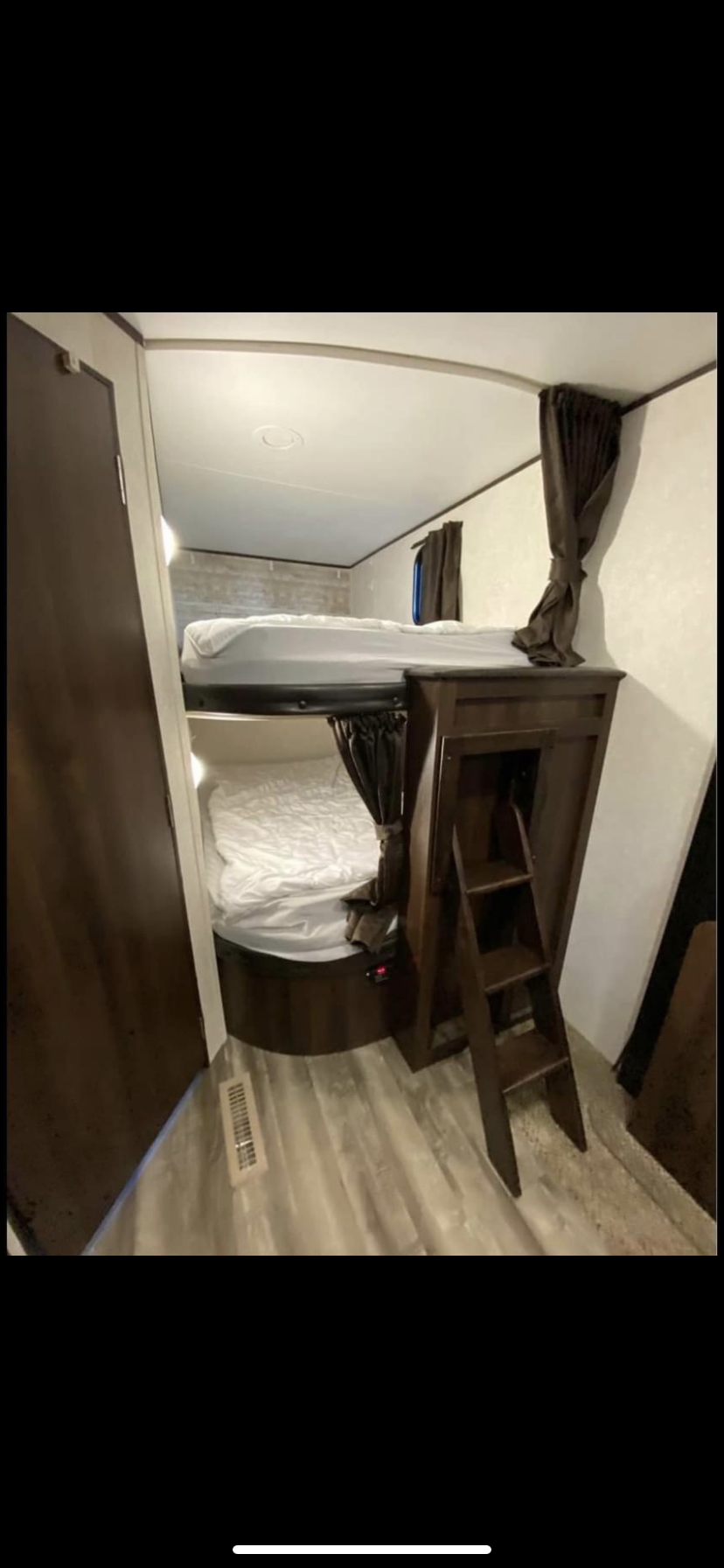 Cozy RV rental bunk beds with ladder and privacy curtains, perfect for family camping.. Jayco Jay Flight 2019