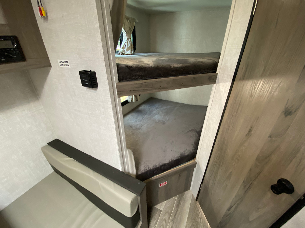 RV rental: view of two bunk beds, a small bench seat, and TV connections, highlighting a compact interior.. Gulf Stream Enlighten 2022