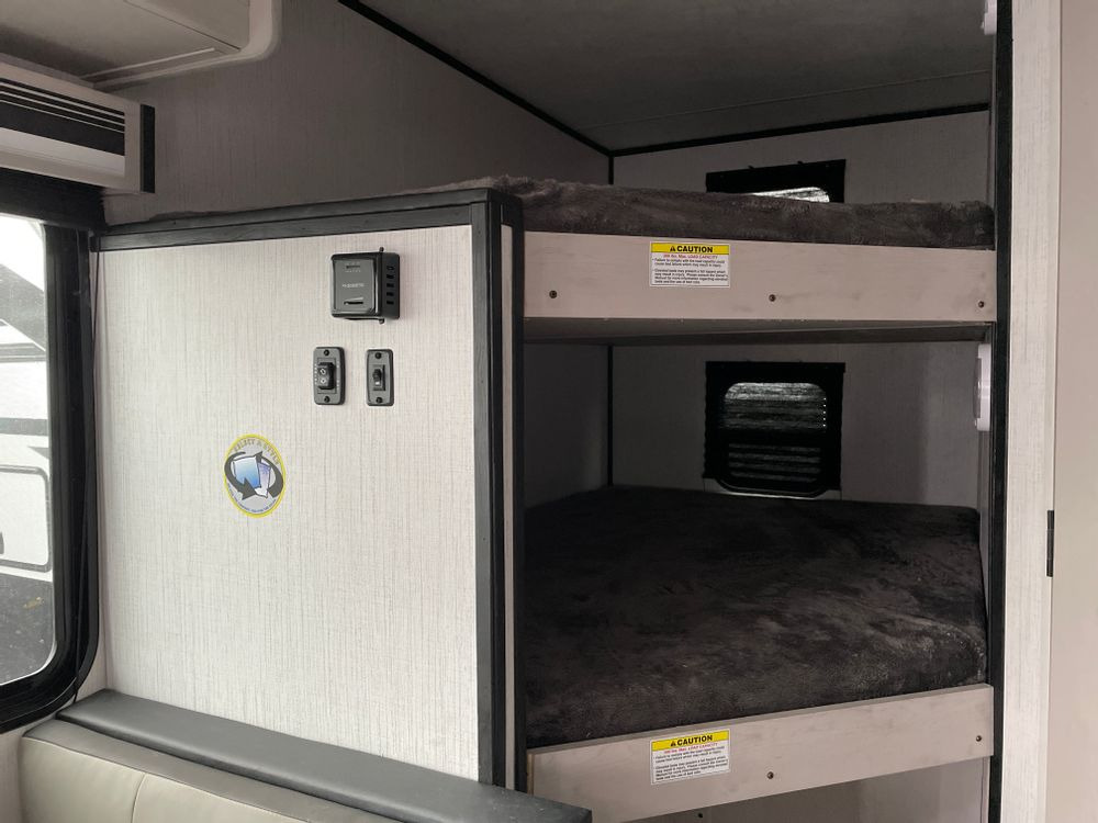 Inside this rv rental, find two levels of cozy bunk beds and convenient control panel, perfect for family travel adventures.. Heartland Mallard 180BH 2022