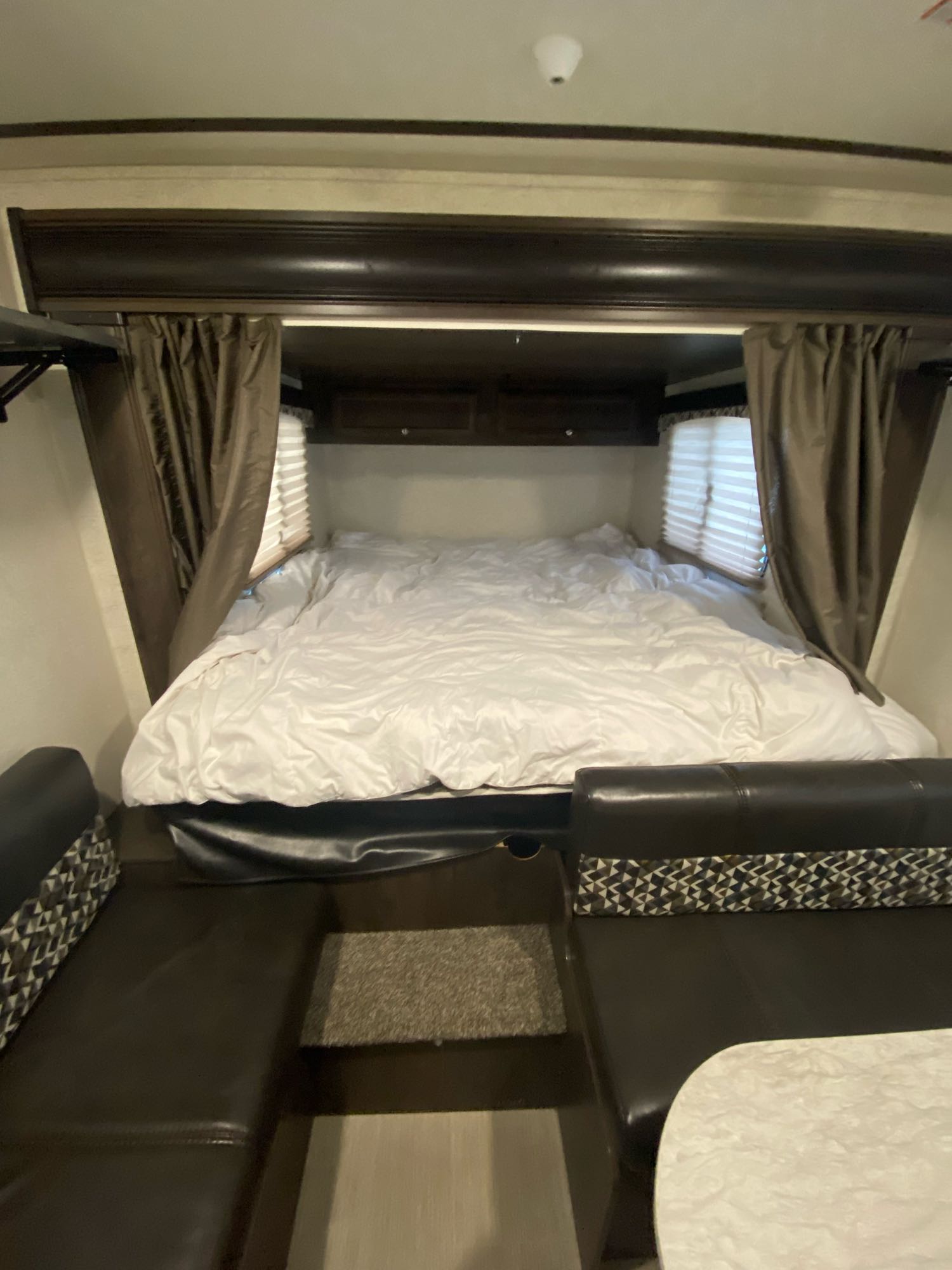 Cozy RV rental interior with a comfortable bed, private curtains, and convenient dinette seating area.. Starcraft Launch Outfitter 2018